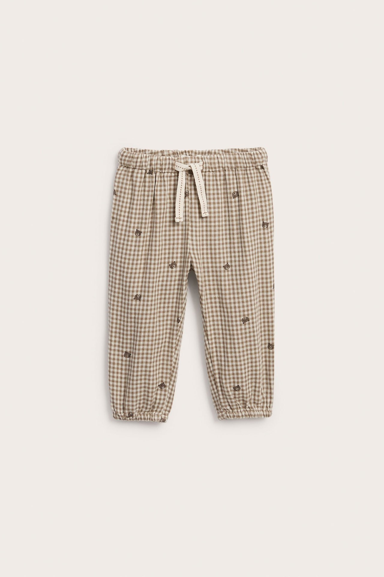 Vorderansicht von Kinderhose in Braun-Beige-Ginghammuster mit Tierstickerei und Kordelzug in der Taille.