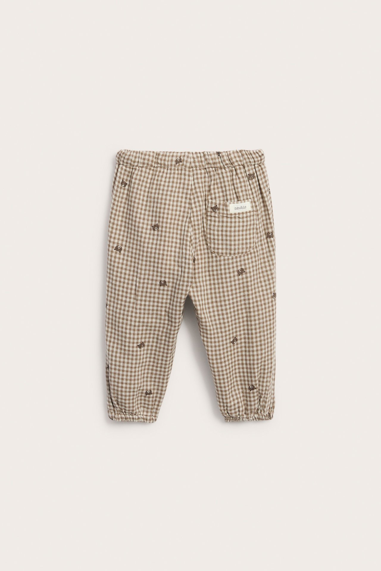 Vorderansicht beiger karierter Babyhose mit kleinen aufgestickten Bären und Gummibund.