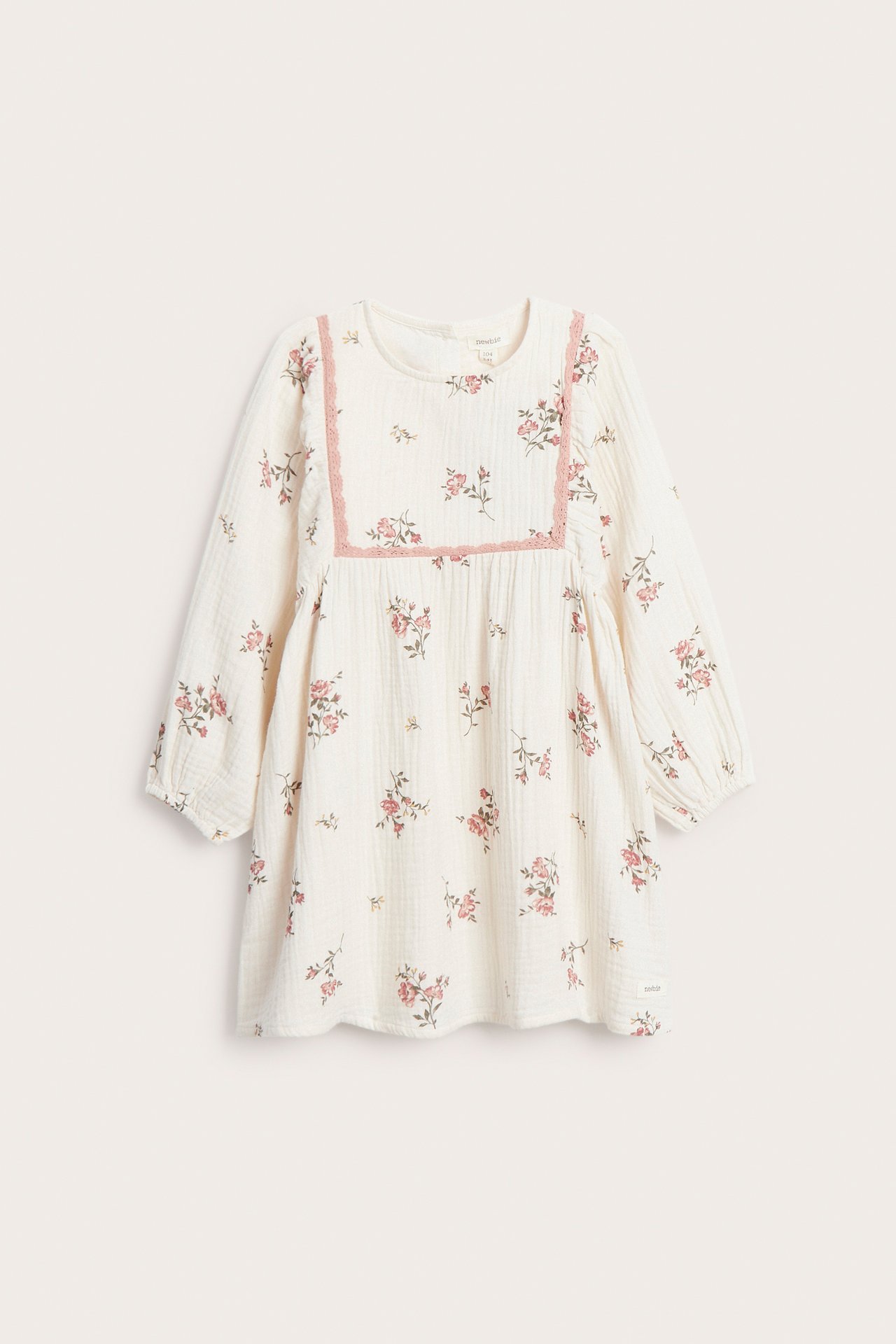 Front view of an off-white kid's floral muslin dress with long sleeves and pink lace trim.