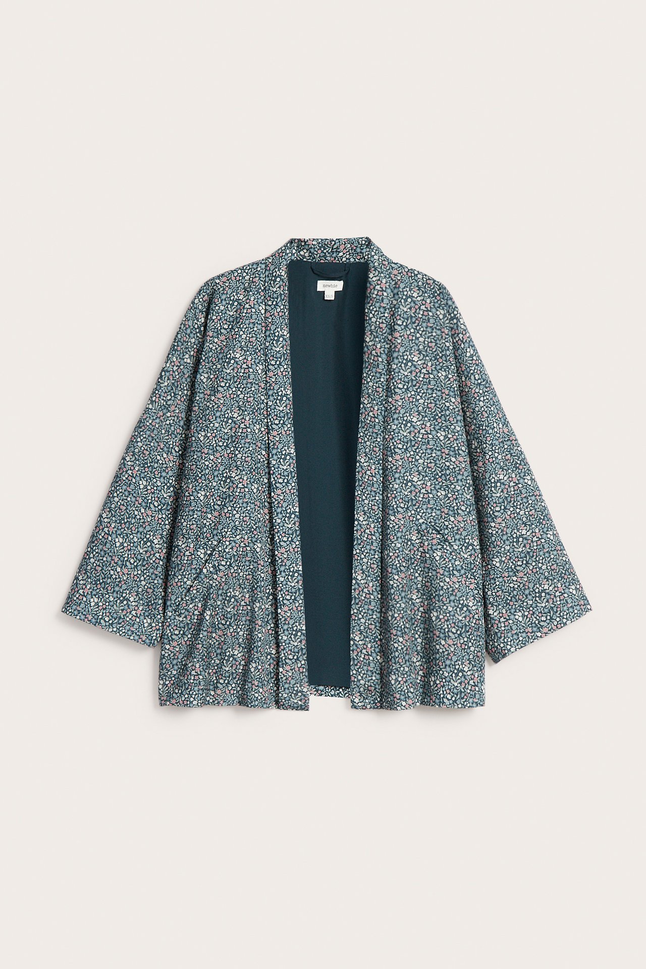 Vorderansicht einer dunkeltürkisen Kimono-Strickjacke mit rosa-weißem Blumenmuster.