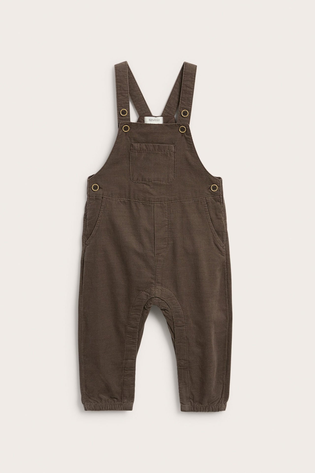 Vorderansicht brauner Cord-Baby-Latzhose mit Brusttasche und Metallverschlüssen.