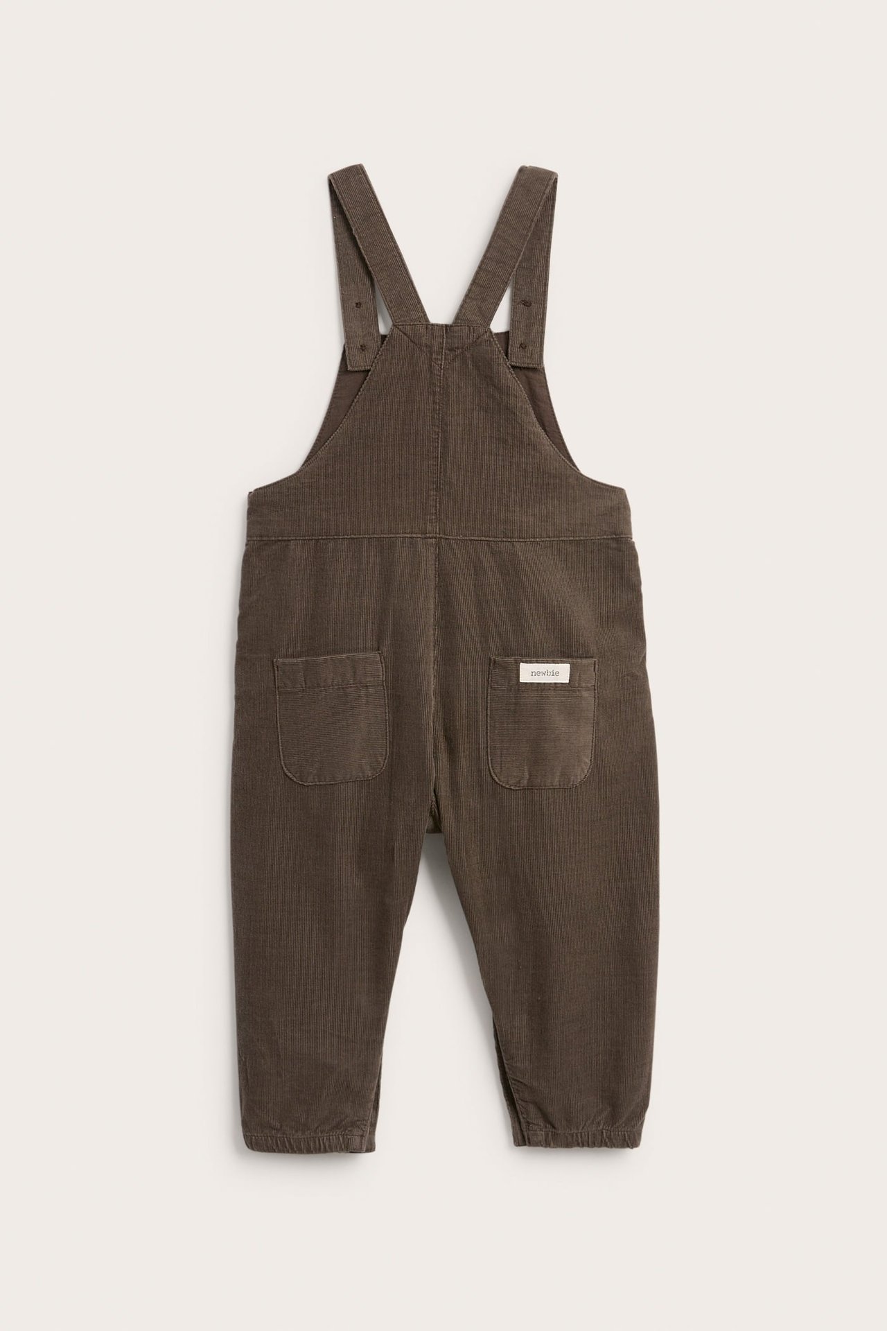 Dunkelbraune Baby-Latzhose aus Cord, Rückansicht, mit verstellbaren Trägern und zwei Taschen.