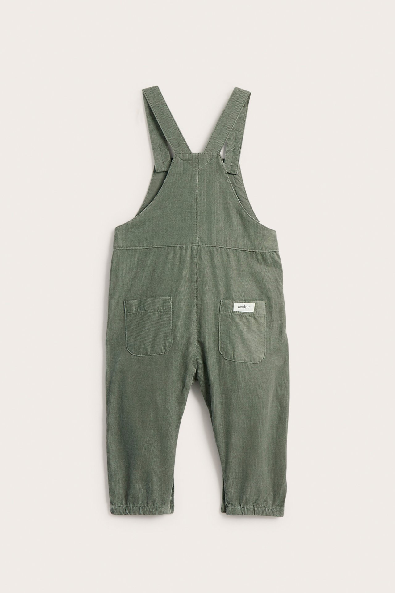 Back view baby green textured overalls with adjustable straps and back pockets.
