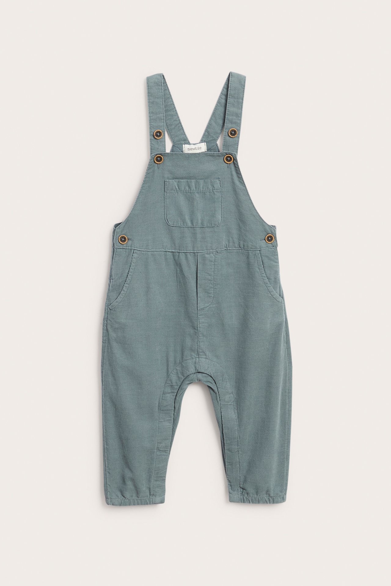 Vorderansicht, Baby-Latzhose aus staubblauem Cord mit Holzknöpfen.