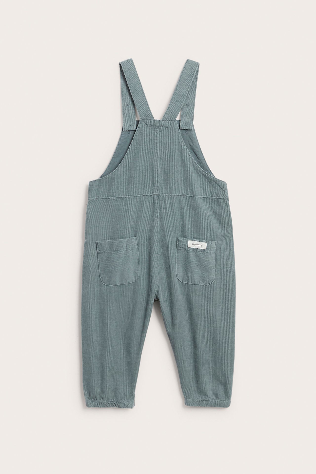 Vorderansicht eines Baby-Overalls in Petrol mit zwei Gesäßtaschen und verstellbaren Trägern.