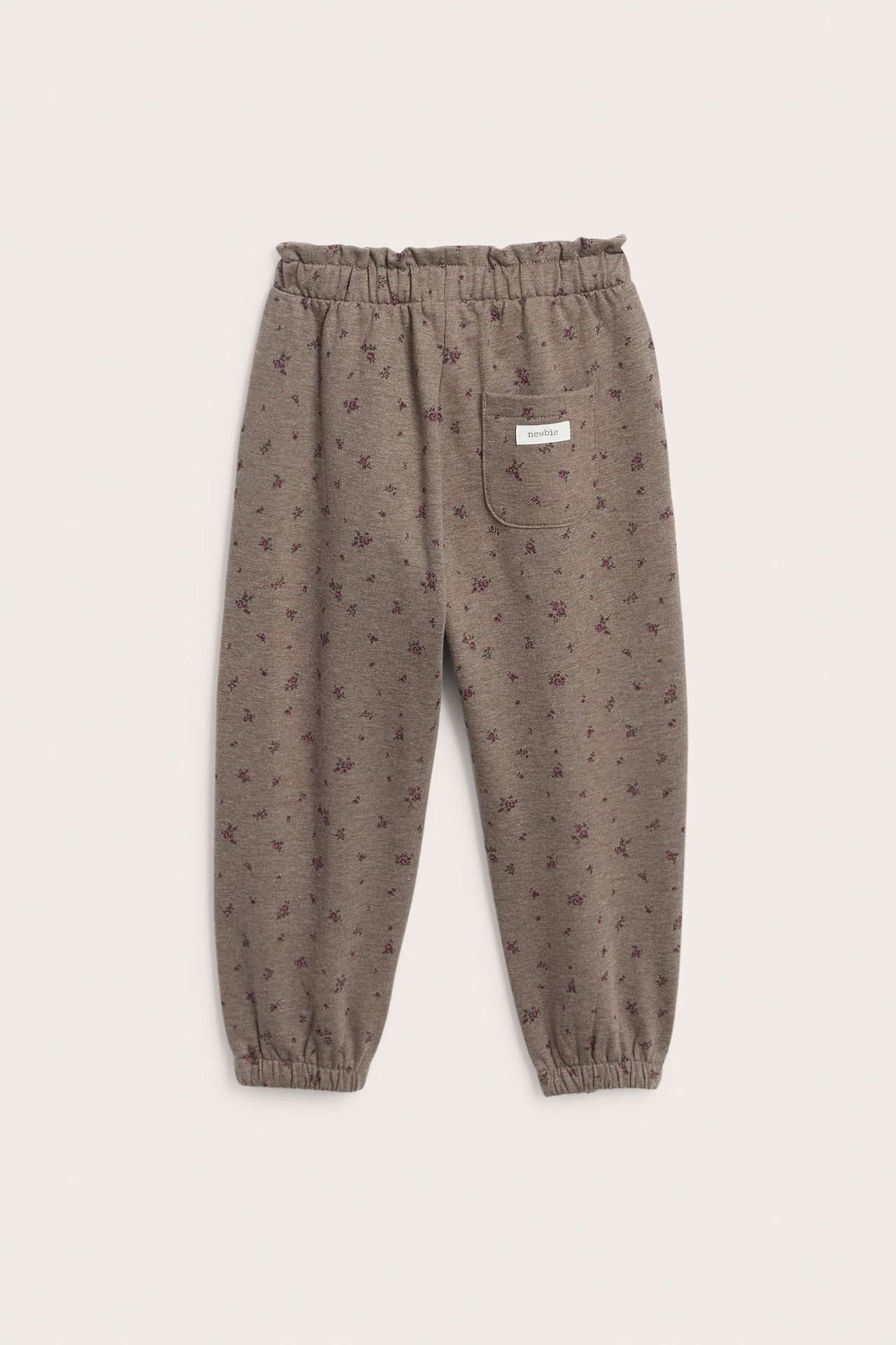 Vorderansicht: braune Baby-Jogginghose mit Blumenmuster, Gummizug an Taille, Knöcheln, Tasche.