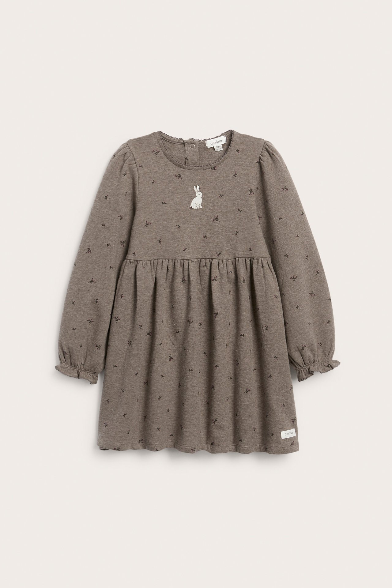 Vorderansicht Kinderkleid in Graubraun mit kleinem Schleifenmuster, weißer Hasenstickerei und Rüschenbündchen.