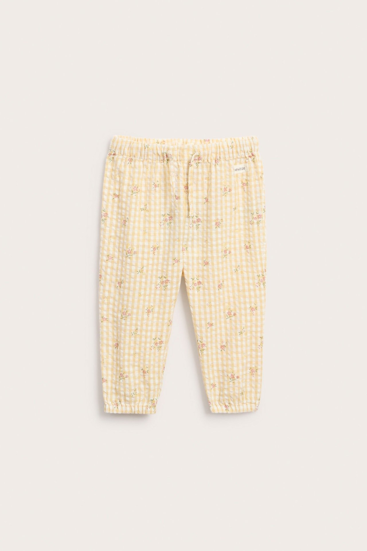 Front view: Kid's yellow gingham cotton trousers with small pink floral print, elastic waist and cuffs.