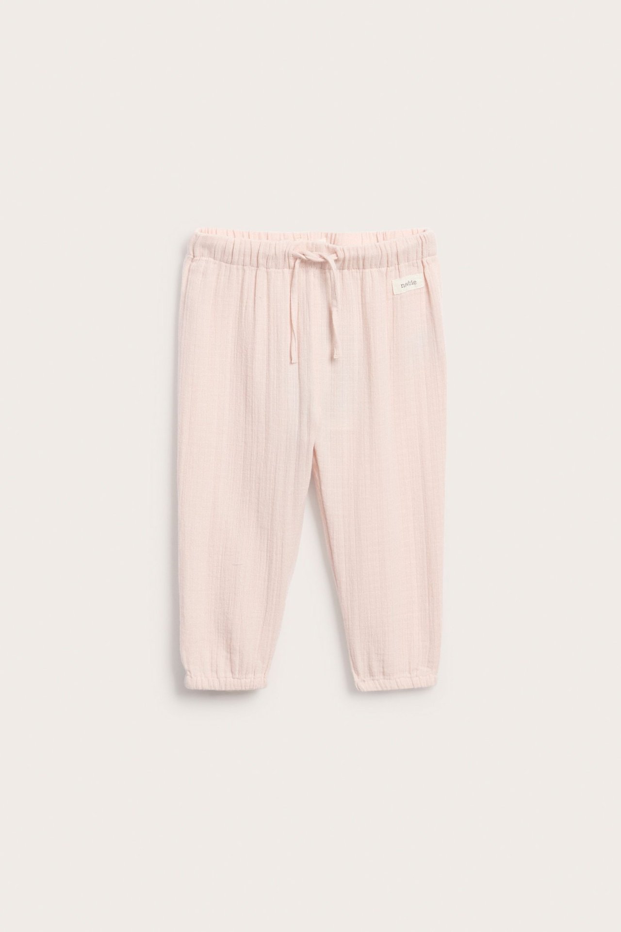 Front view of light pink woven cotton kid's pants with elastic drawstring waist and elastic cuffs.