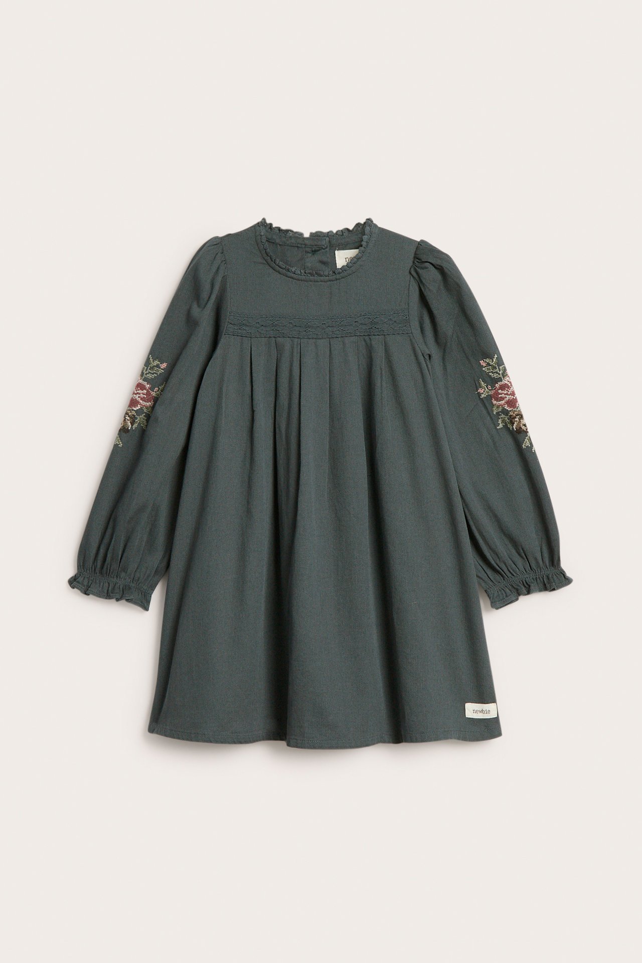 Vorderansicht, dunkelgrünes Kinderkleid mit langen bestickten Ärmeln und Rüschenausschnitt.