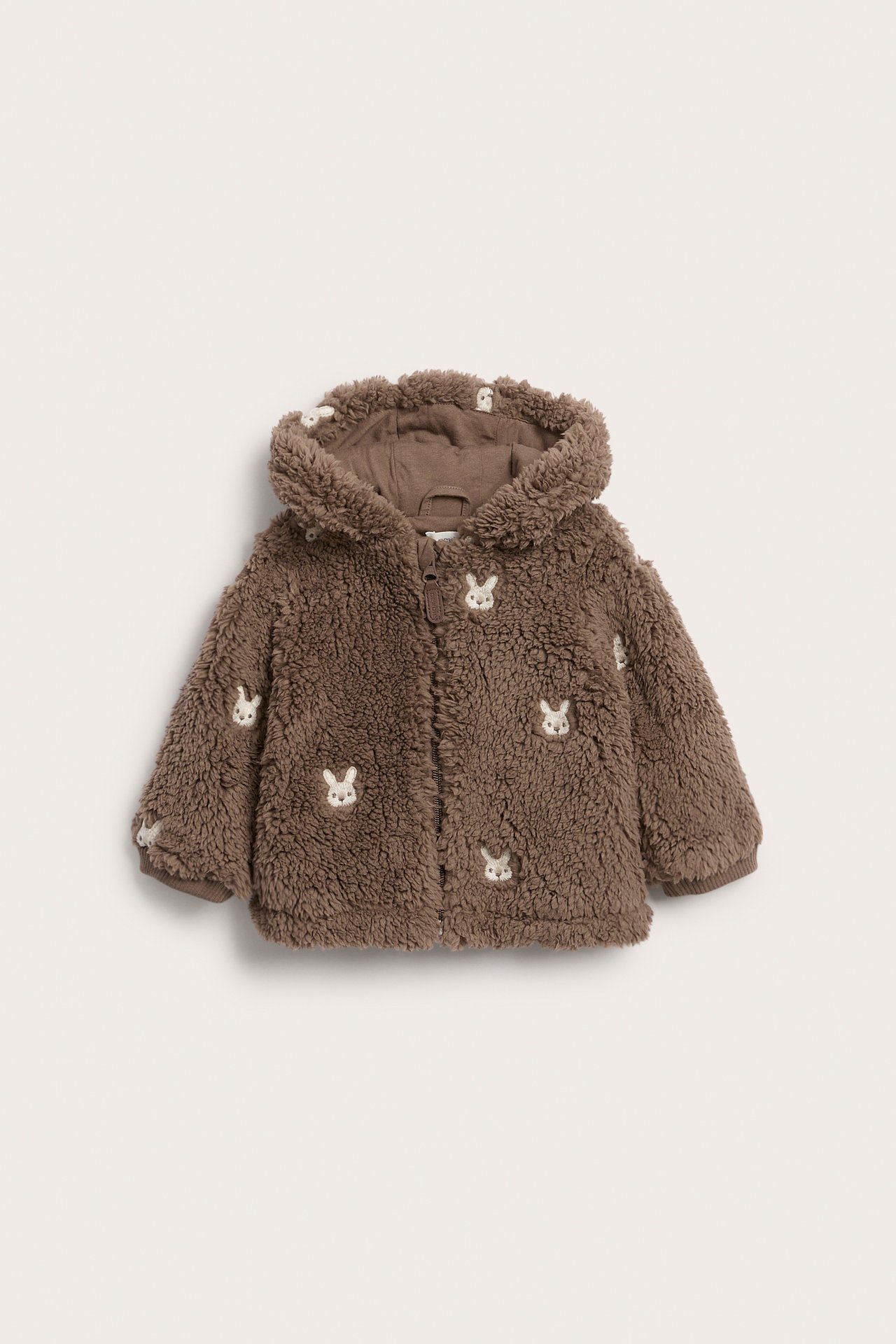 Vorderansicht: Braune flauschige Baby-Kapuzenjacke mit weißen Hasenstickereien und Reißverschluss.