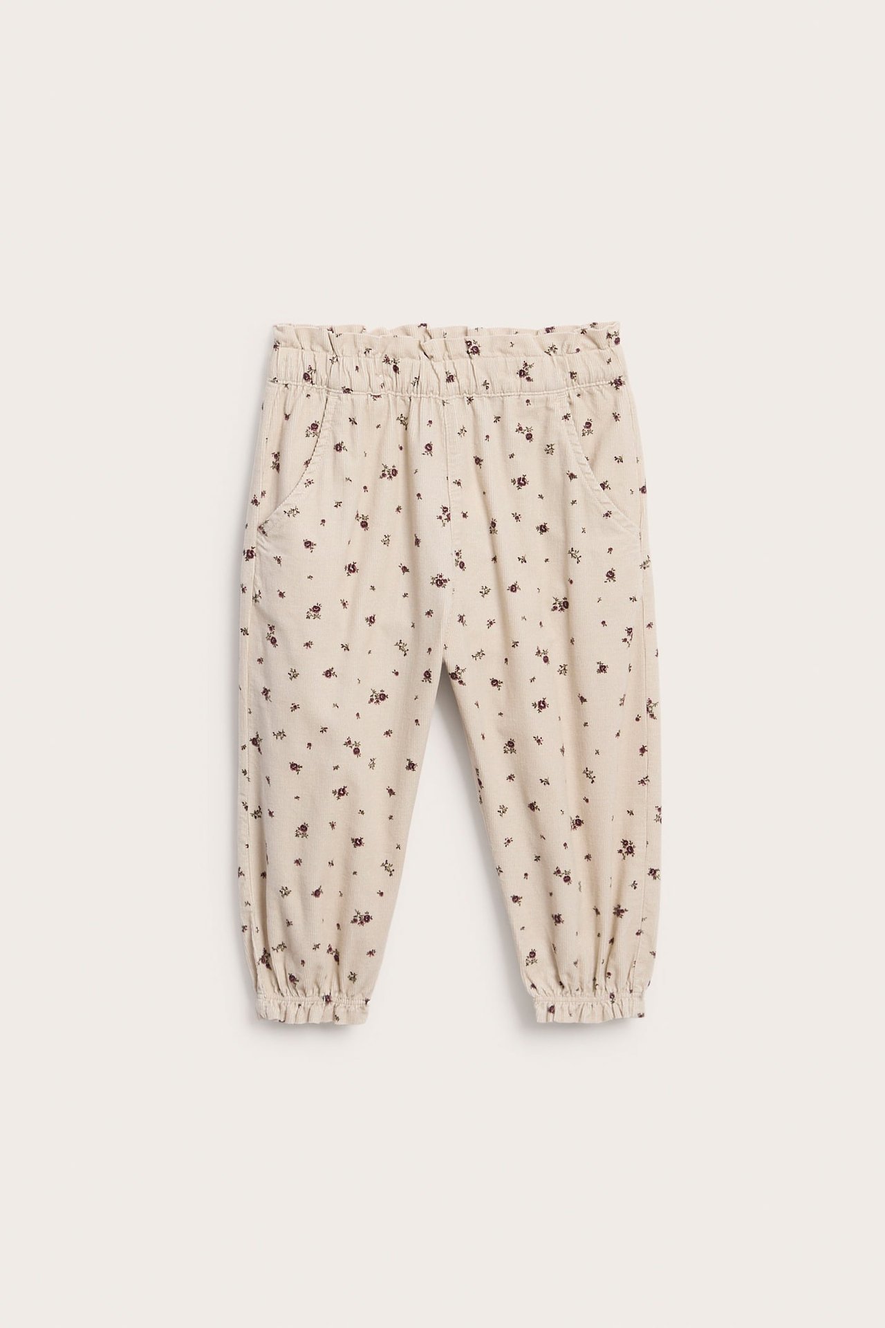 Vorderansicht von beiger Jogginghose mit Blumenmuster und Gummizug an Taille und Bündchen für Kinder.