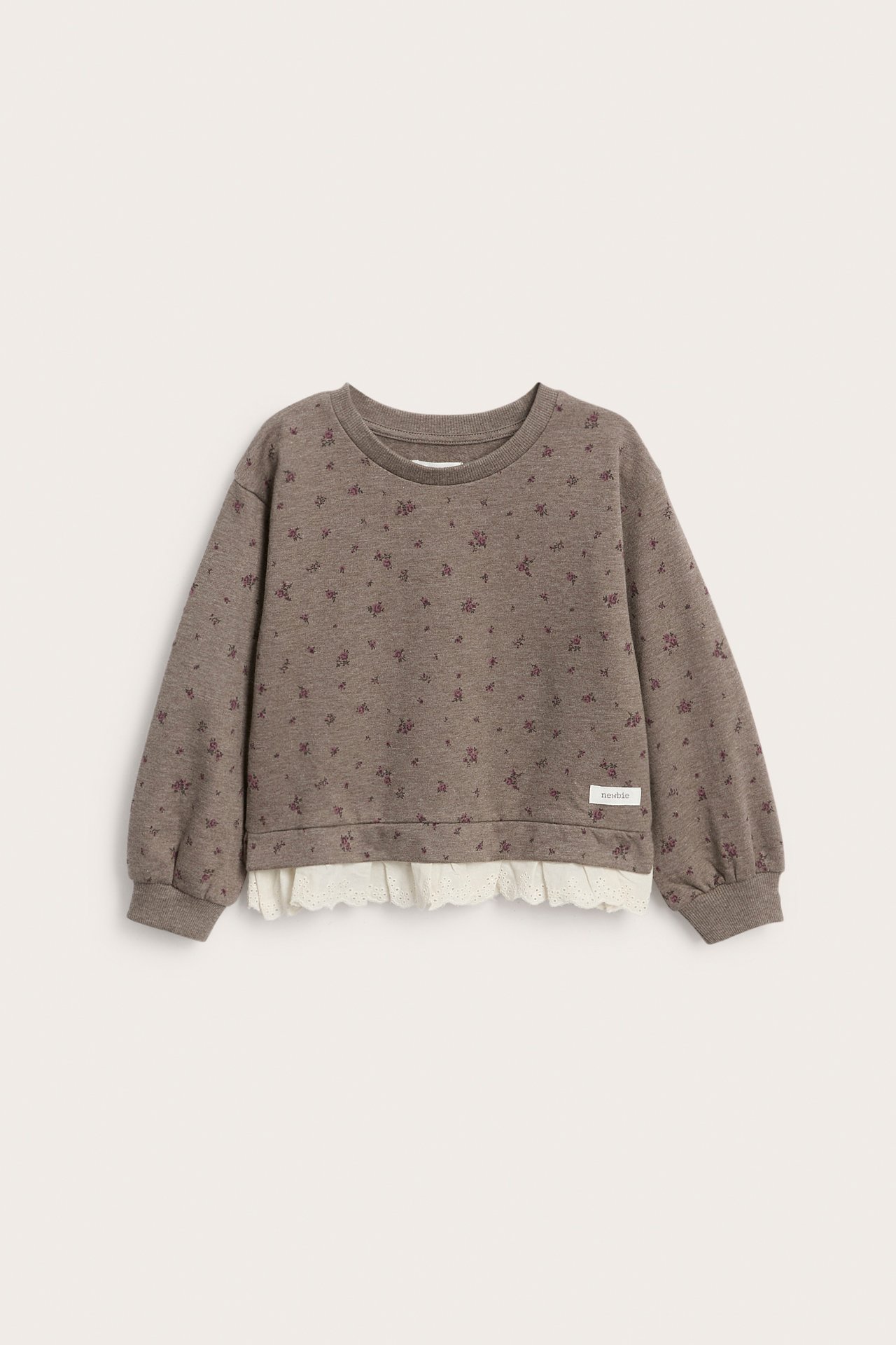 Vorderansicht eines braunen gemusterten Kindersweatshirts mit weißem Spitzenvolant.