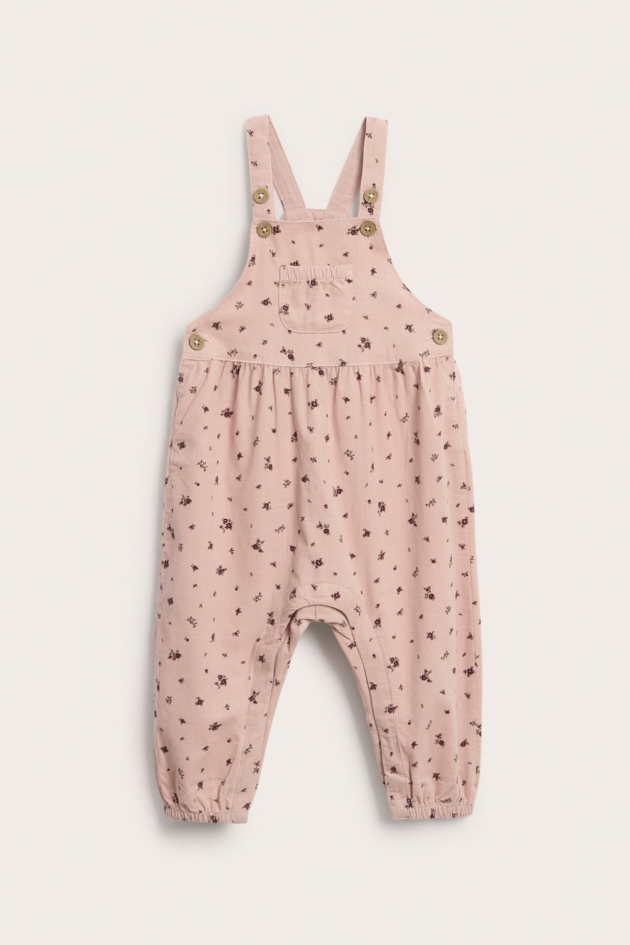 Vorderansicht, babyrosa Overall mit Blumenmuster, Knöpfen an den Trägern und Vordertasche.