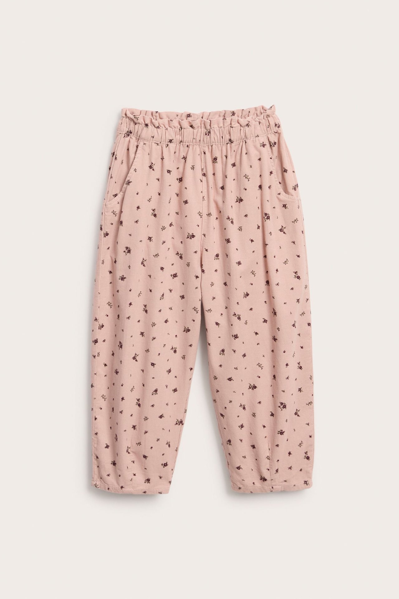Vorderansicht: Kinderhose aus rosa Blumenstoff mit Gummizug in Taille und Bündchen.