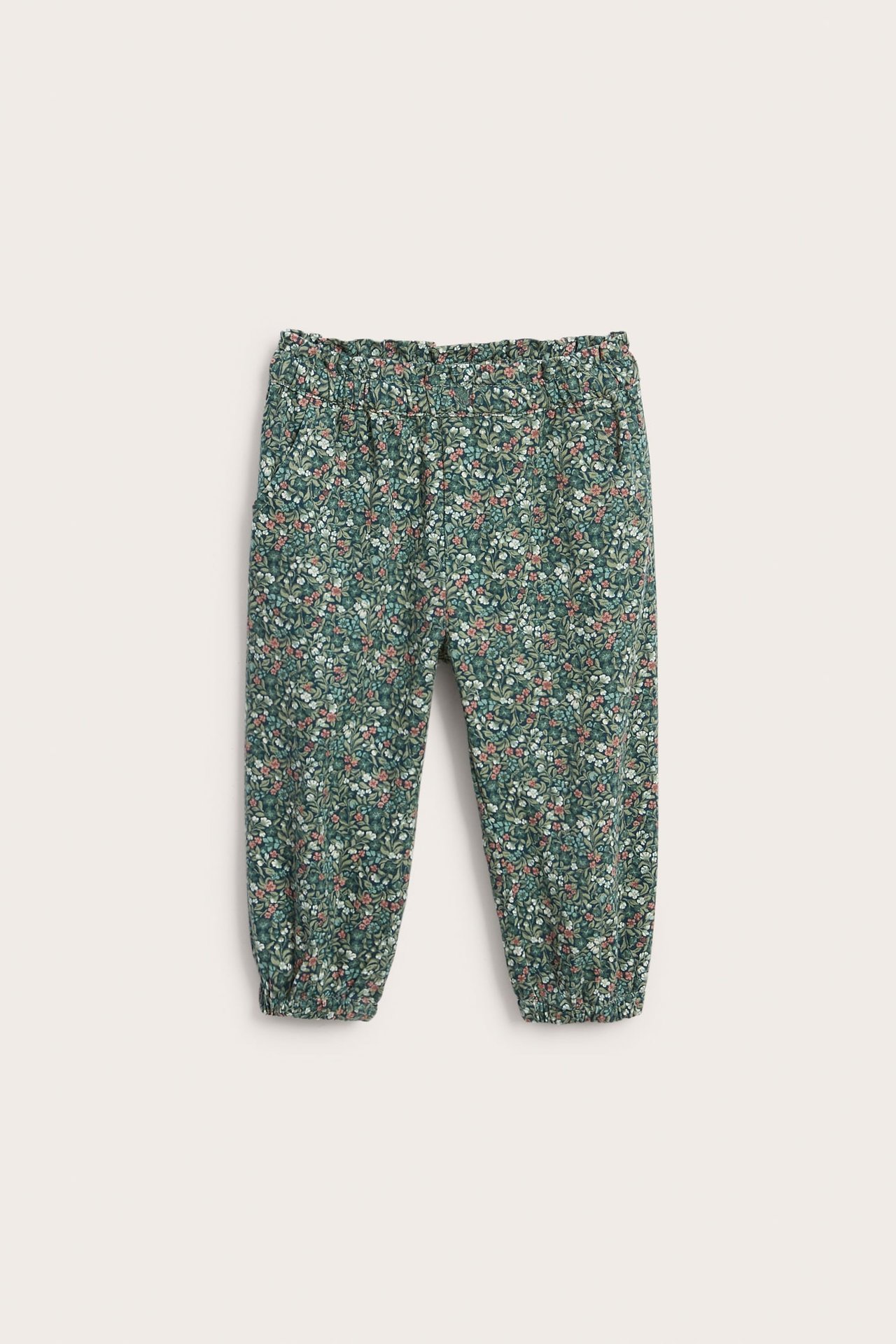 Kid's green floral print pants with elasticated waist and cuffs, front view.