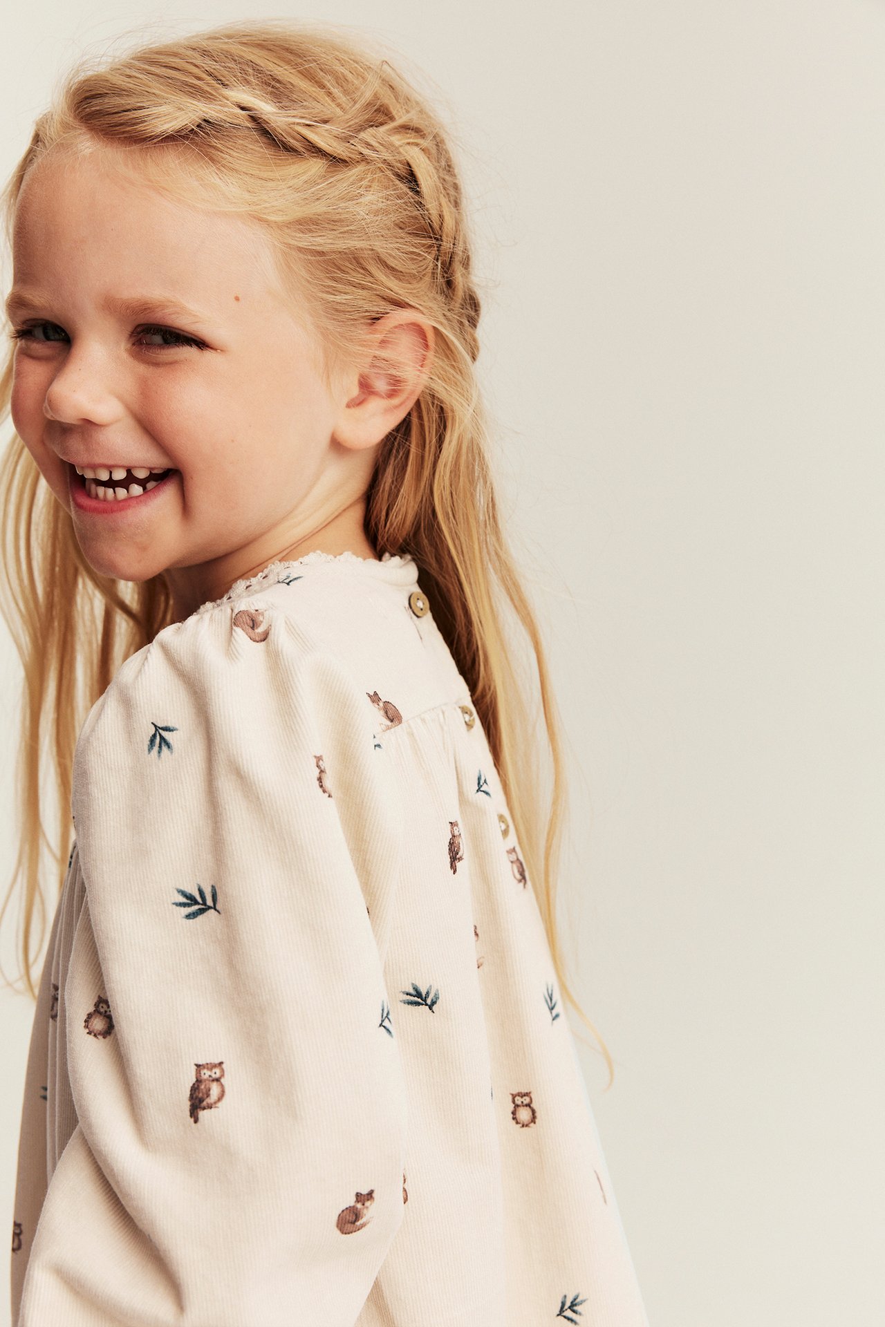 Kinder-Bluse aus ecrufarbenem Cord mit Eulen- und Blättermuster, Knopfverschluss, Seitenansicht.