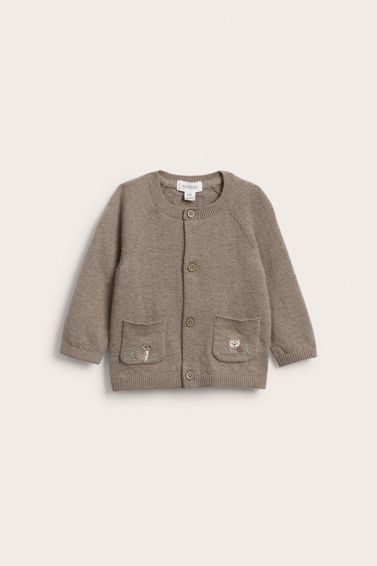 Vorderansicht einer braunen gestrickten Babyjacke mit Knopfverschluss und bestickten Taschen.