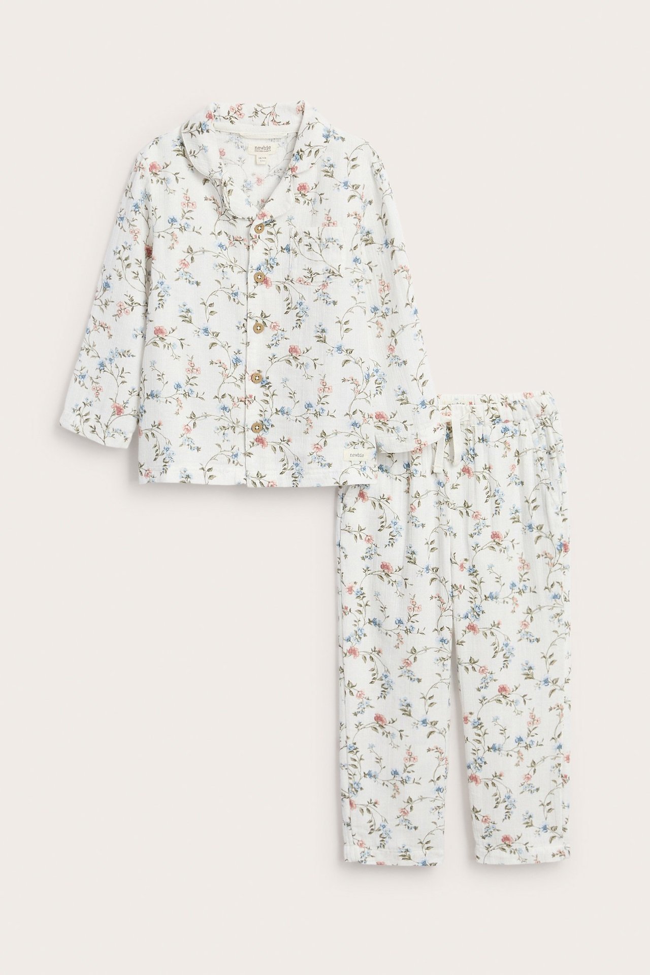 Vorderansicht: Offwhite zweiteiliger Kinder-Pyjama aus Baumwolle mit blau-rosa Blumenmuster.