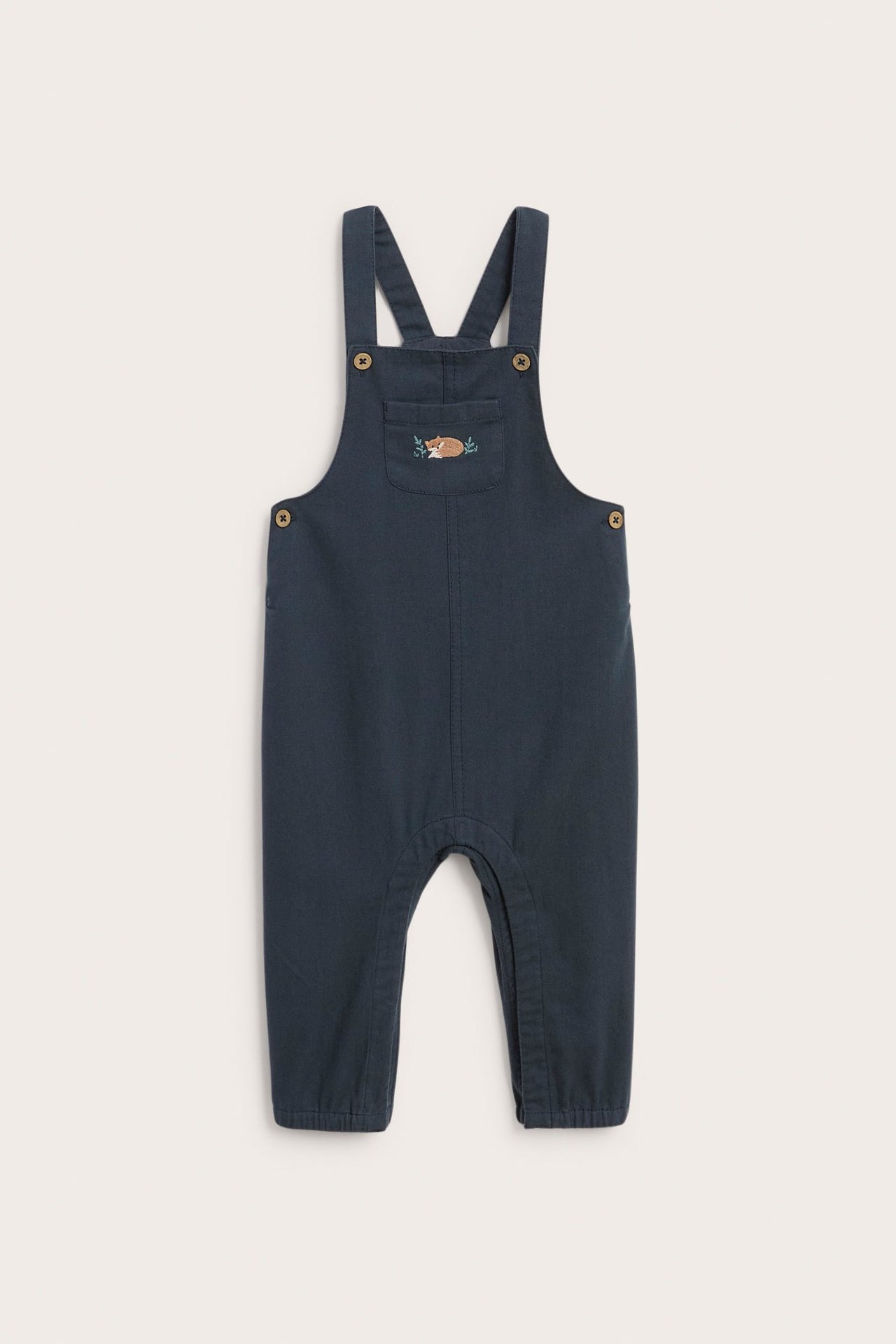 Vorderansicht eines dunkelblauen Baby-Overalls mit gesticktem schlafenden Fuchs und Blättern auf der Brusttasche.
