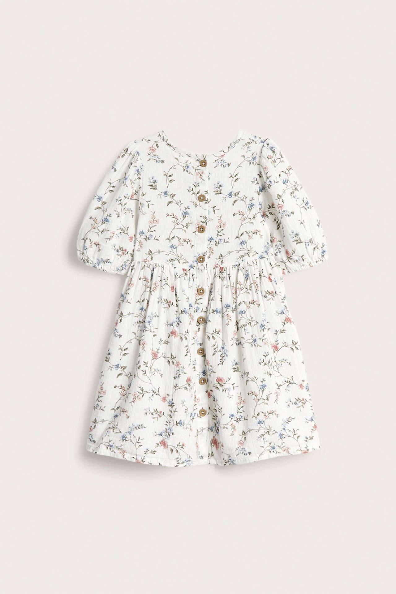 Front view of an off-white kid's floral puff-sleeved dress with button details and gathered waist.