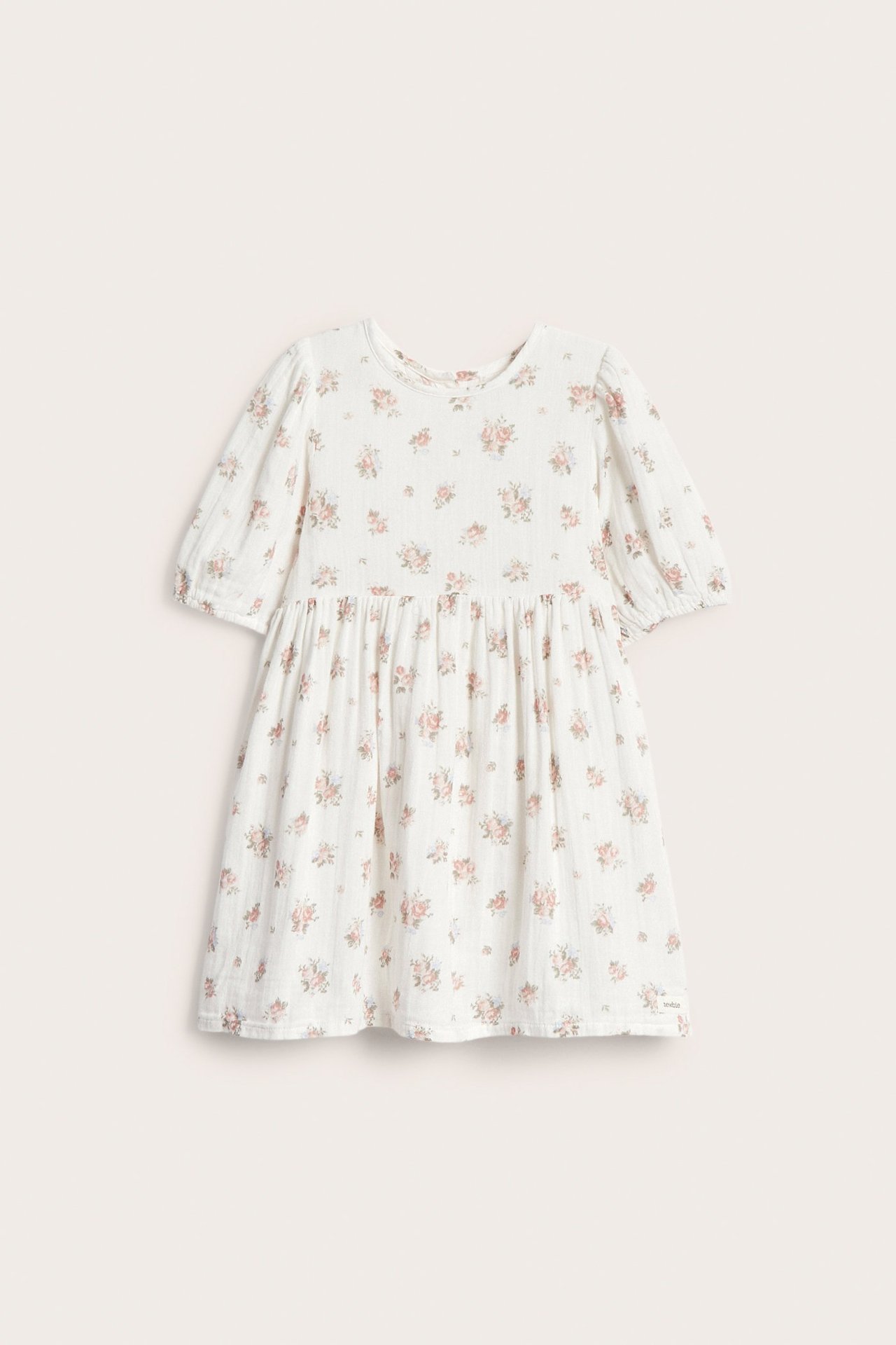 Front view: Off-white kid's cotton dress with pink floral pattern, short puff sleeves, gathered waist.