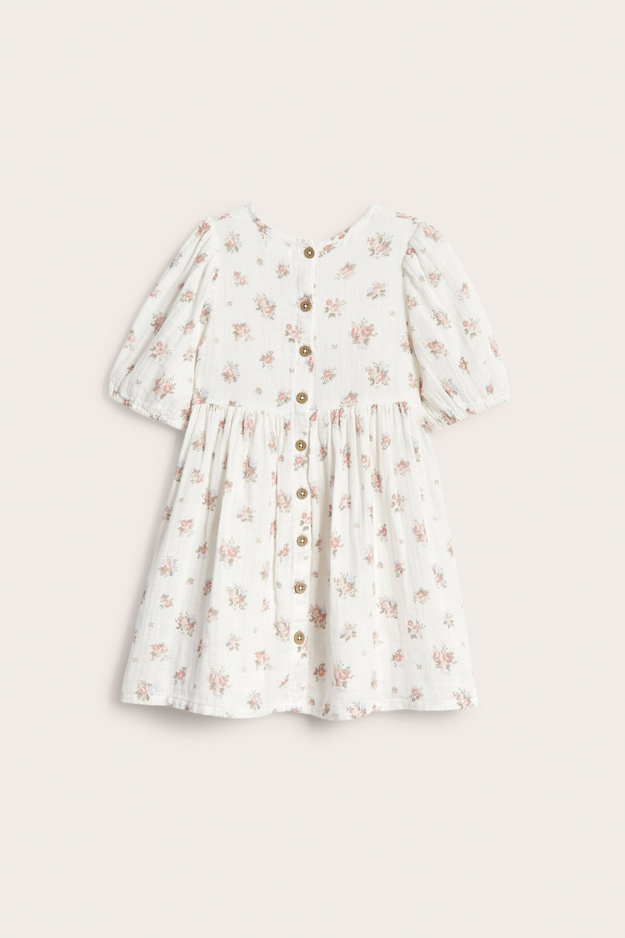 Front view of an off-white kid's dress with pink floral print, short puff sleeves, and front button closure.