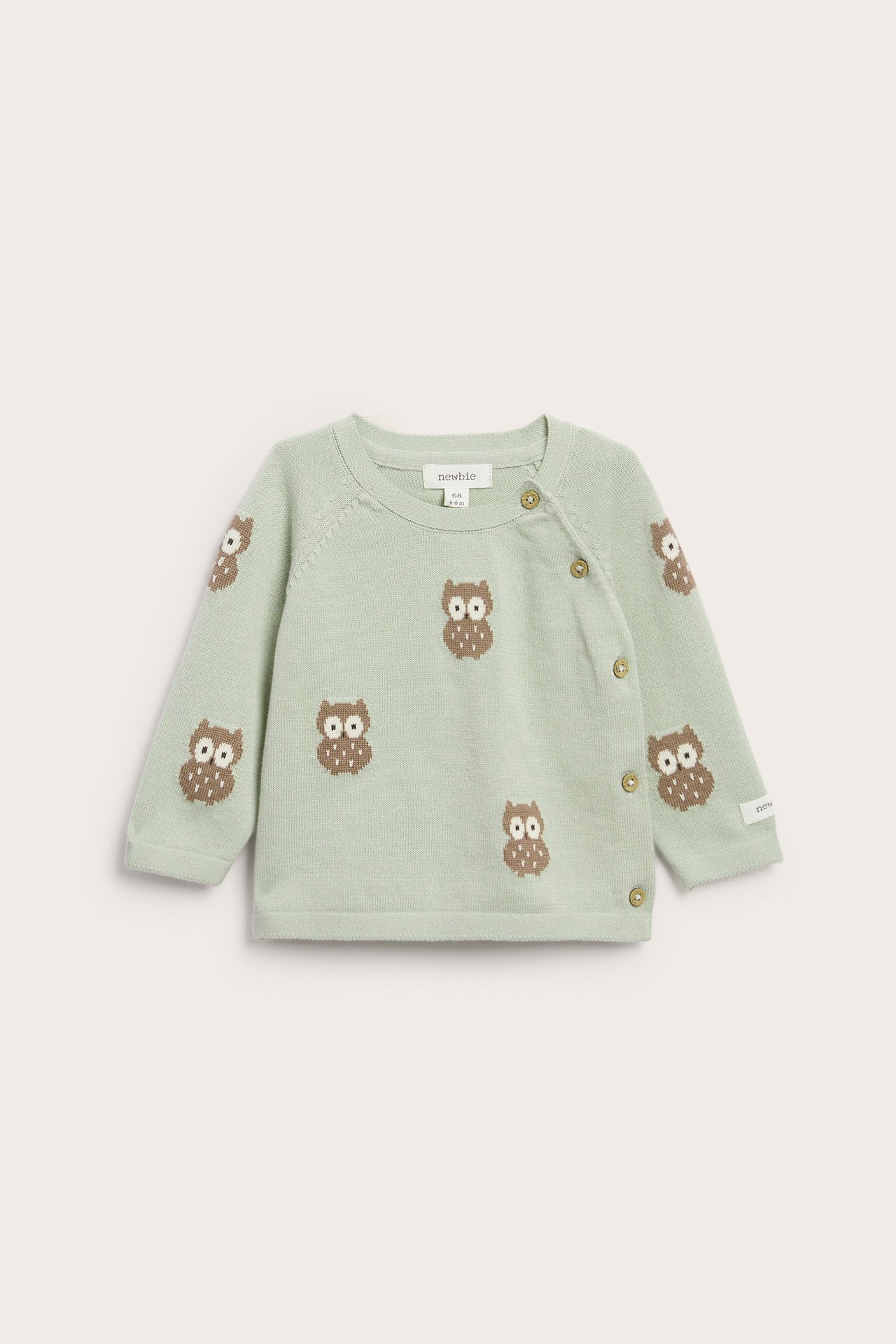 Vorderansicht einer hellgrünen Strickjacke für Babys mit braunem Eulenmuster und seitlichen Knöpfen.