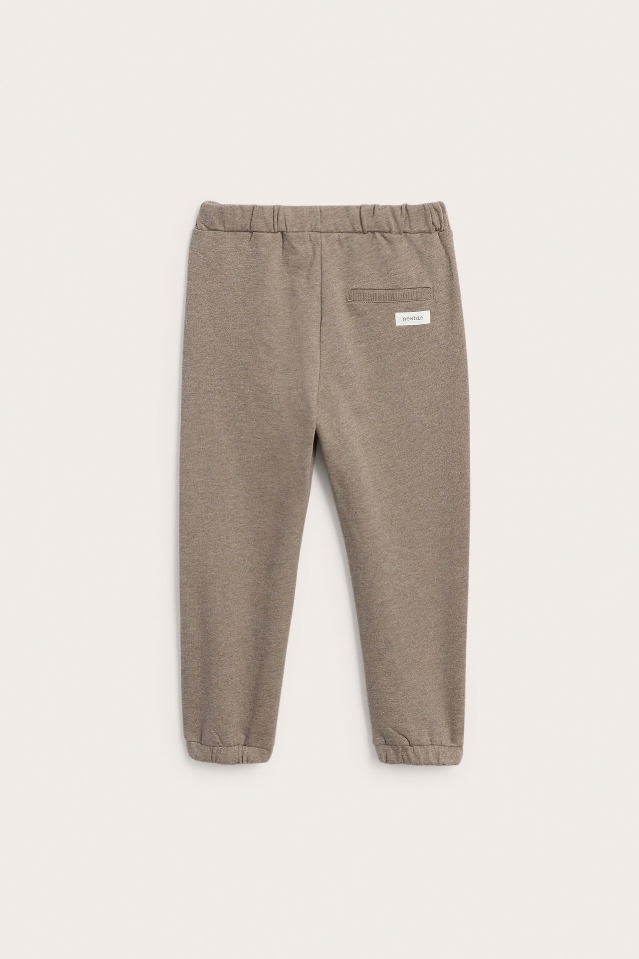 Rückansicht von taupefarbenen Sweatpants mit Gummibund und elastischen Bündchen, ein kleines Etikett.