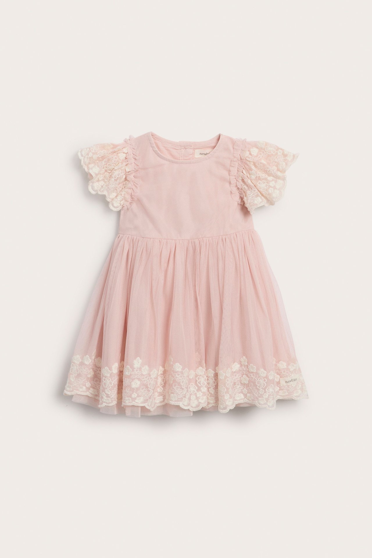 Vorderansicht eines rosa Babykleides mit kurzen Spitzenärmeln und einem Tüllrock mit Spitzenbesatz.