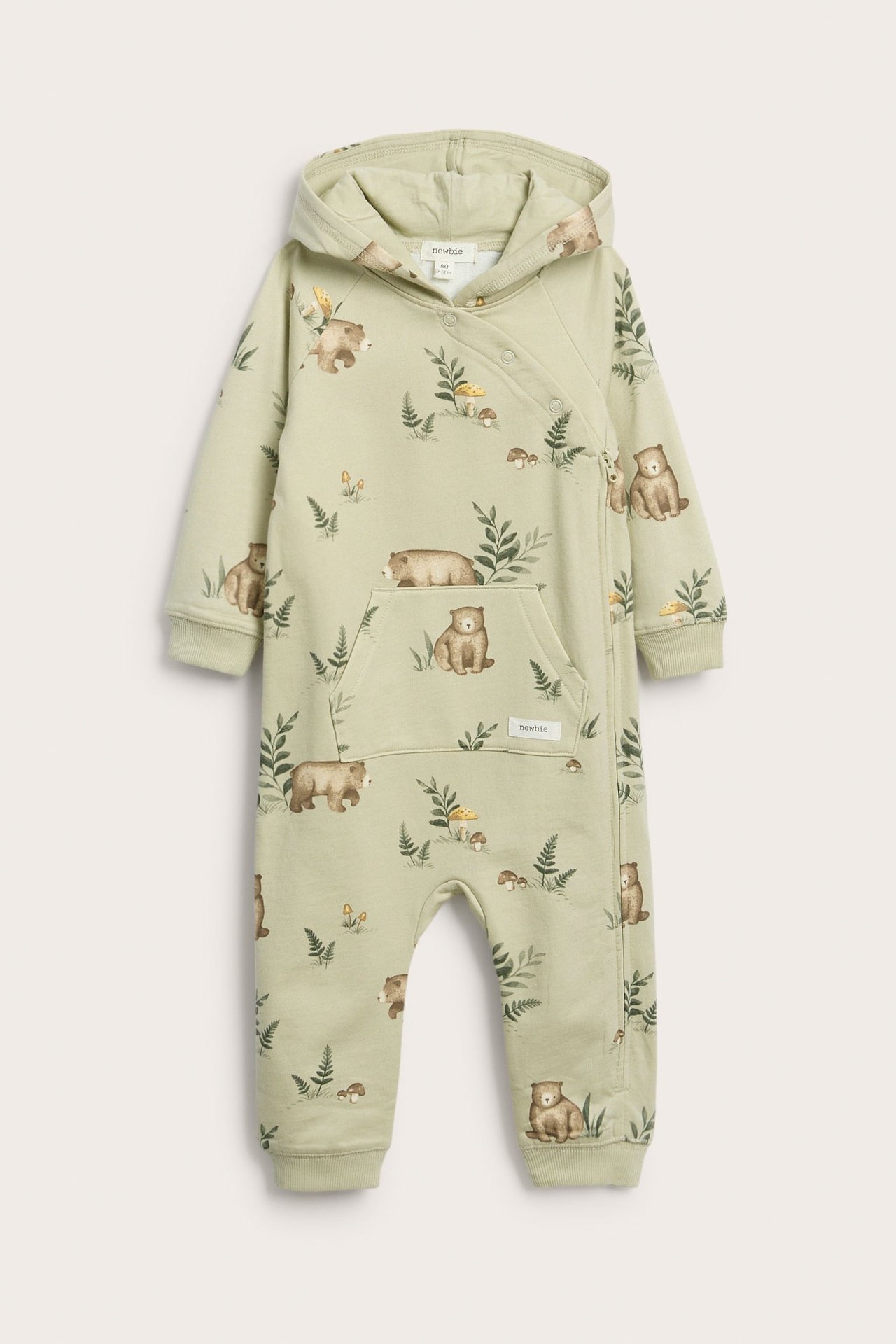 Vorderansicht eines babyhellgrünen Kapuzenoveralls mit Bären- und Farnmuster, Druckknöpfen.