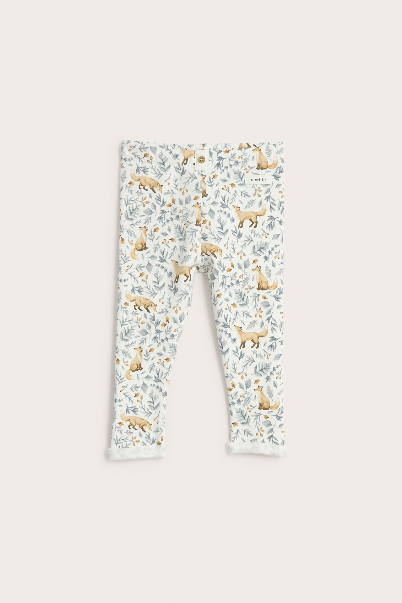 Front view of baby off-white leggings with a fox and foliage print and fluffy cuffs.