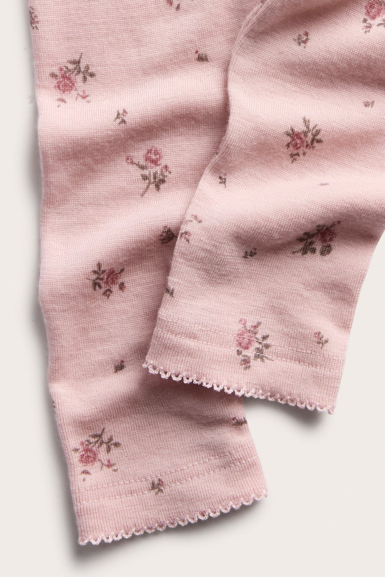 Close-up of pink floral knit bottoms with a scalloped hem.