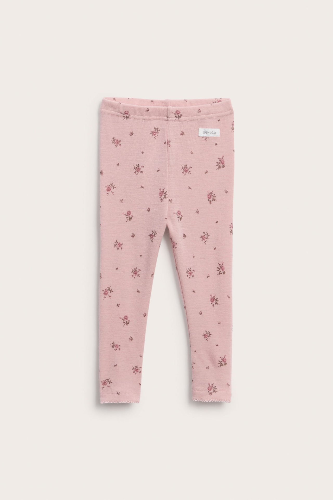 Front view of pink floral print baby leggings with scalloped hems.