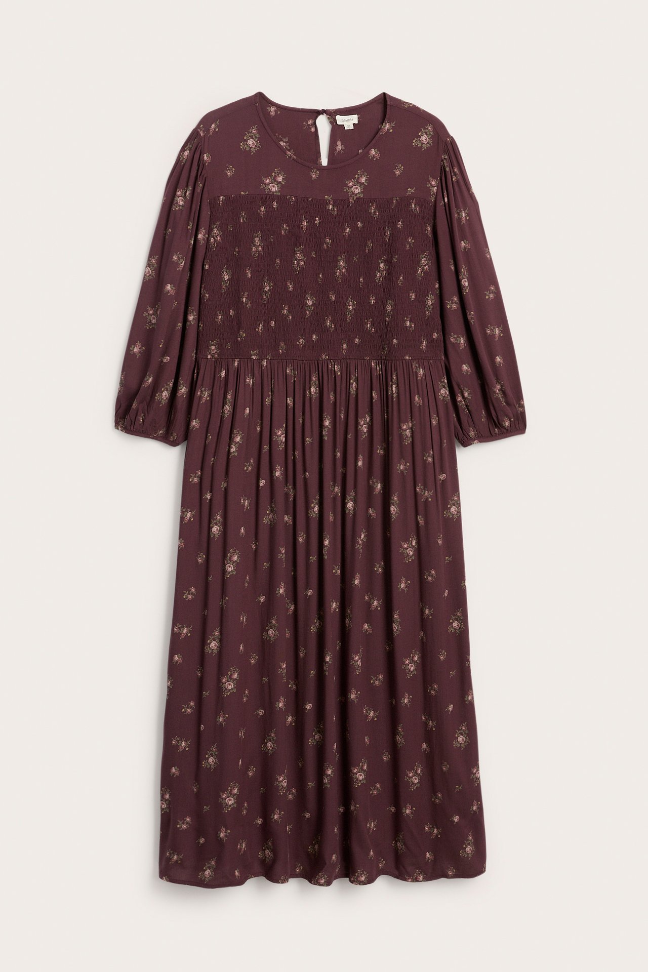 Front view of a dark red smocked maxi dress with a small floral print and long sleeves.