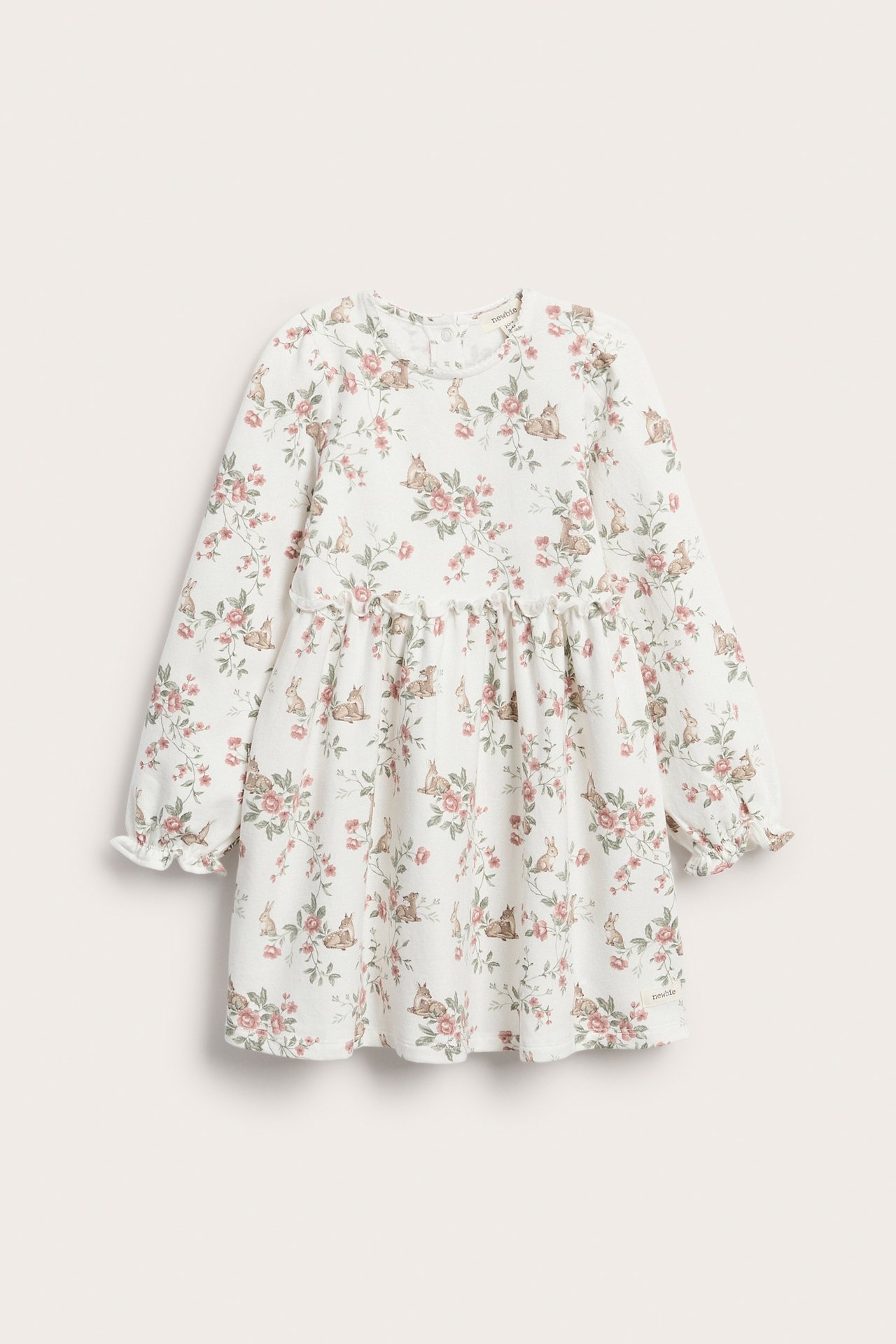 Front view of an off-white kid's jersey dress with pink floral and deer print, gathered waist, and ruffled sleeves.