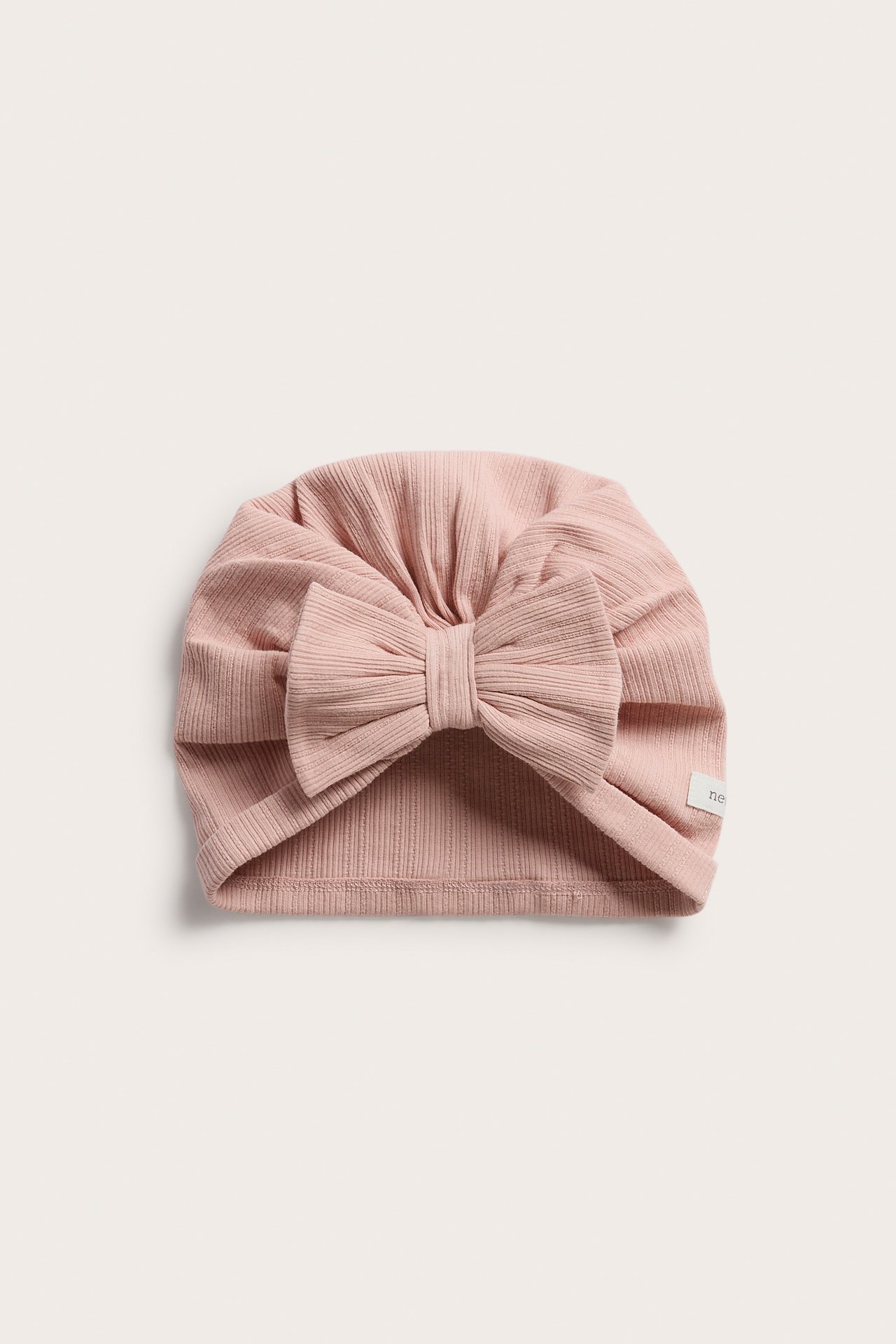 Vorderansicht einer rosa gerippten Jersey-Turbanmütze für Baby/Kind mit großer Schleife.