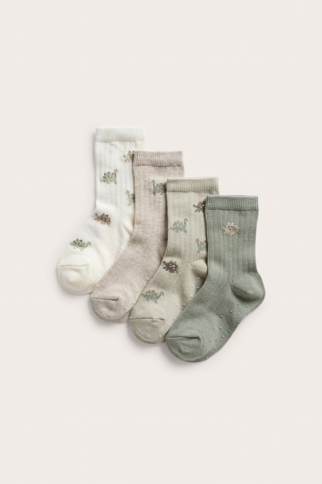 Vorderansicht: Kinder-4er-Pack Rippsocken in Hellgrün, Beige, Cremeweiß, Dinosauriermuster und Anti-Rutsch.