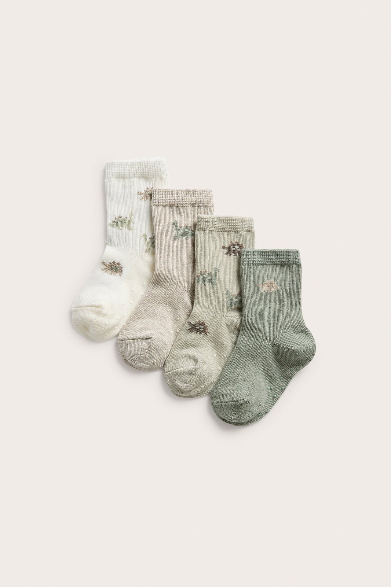 Vier gerippte Baumwollsocken in Hellgrün, Beige, Cremeweiß, mit Dinosaurier-Muster, Antirutsch.