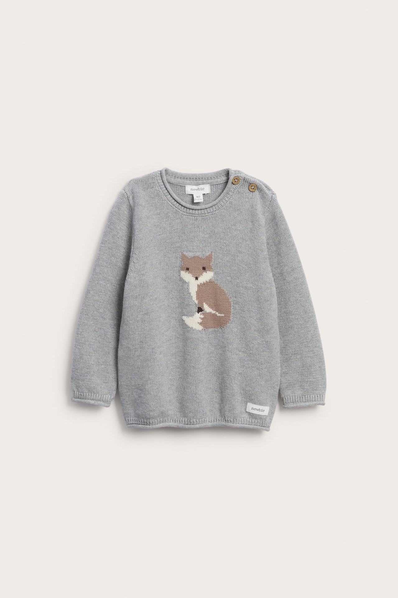 Vorderansicht eines grauen Babystrickpullovers mit Fuchsmotiv, Schulterknöpfen und kleinem Etikett.
