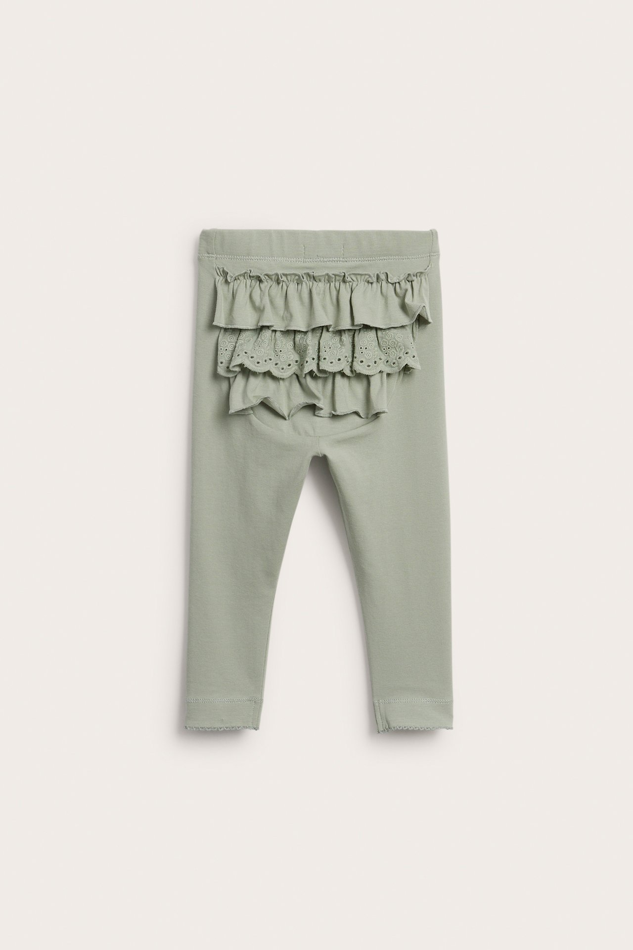 Rückenansicht: Grüne Baby-Baumwoll-Leggings mit Gummibund, Rüschen und Spitzendetails am Po.
