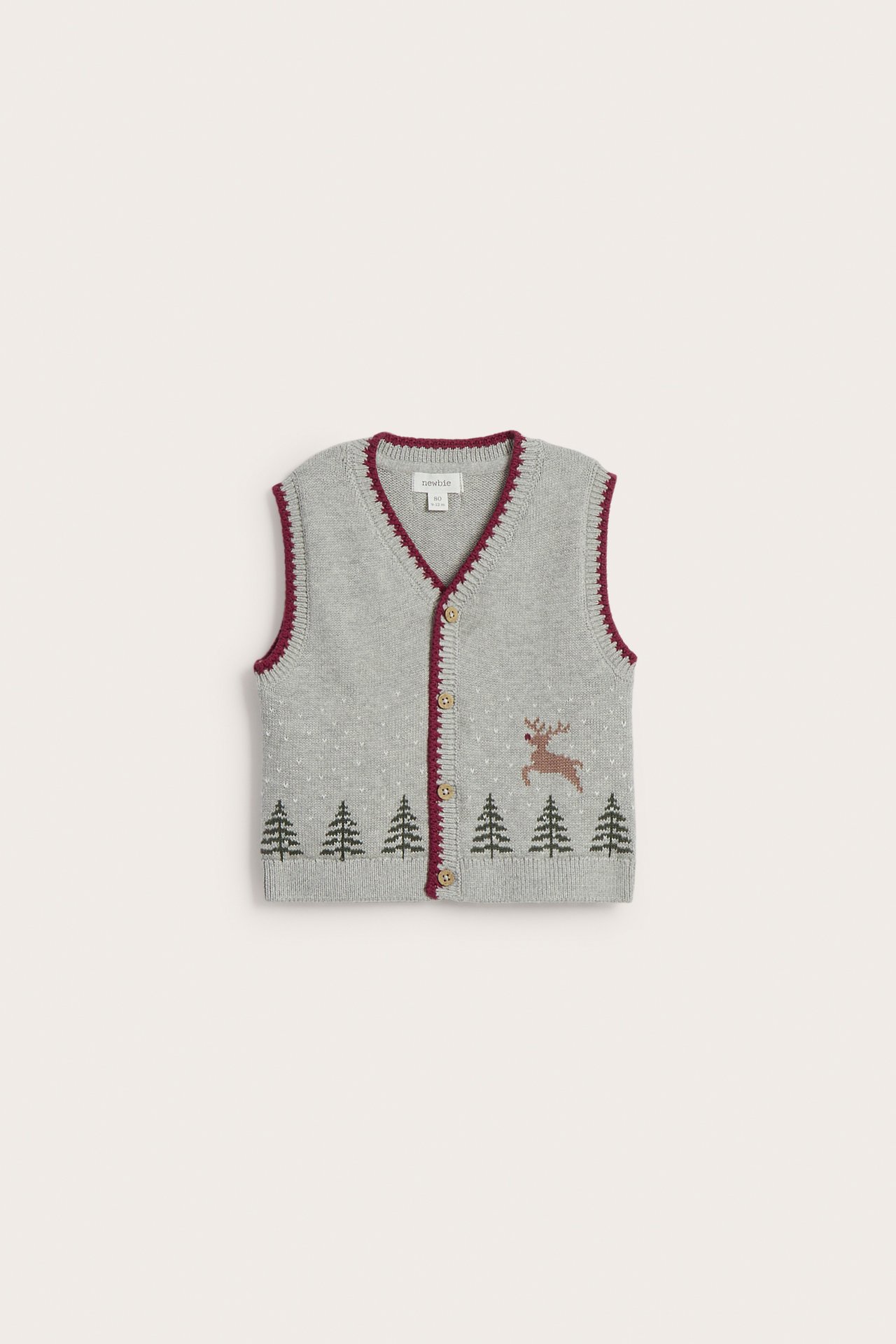 Baby's gray vest with red trim, buttons, green trees, white dots, and brown reindeer.