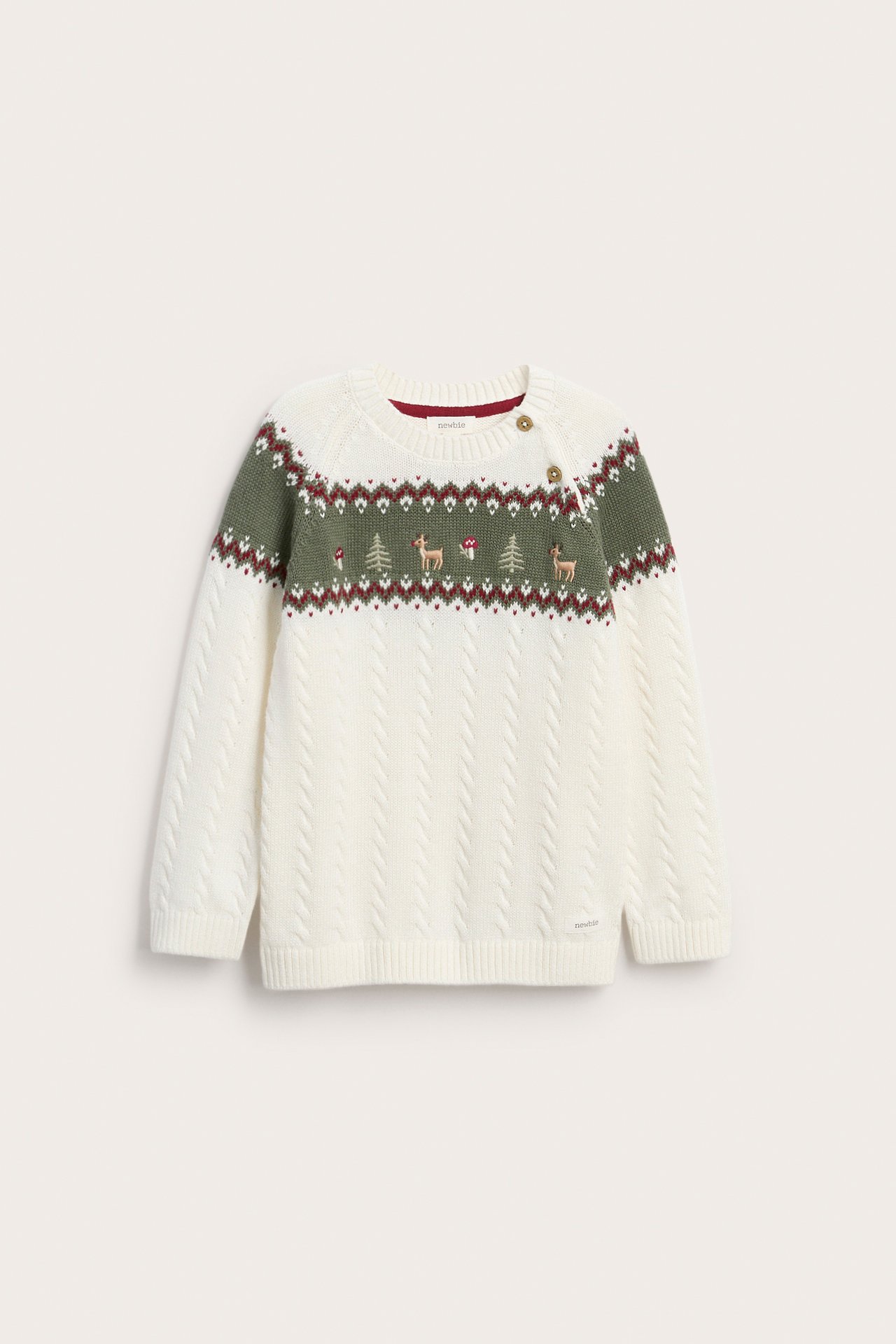 Front view of a kid's cream cable-knit sweater with green, red, and brown fair isle pattern and shoulder buttons.