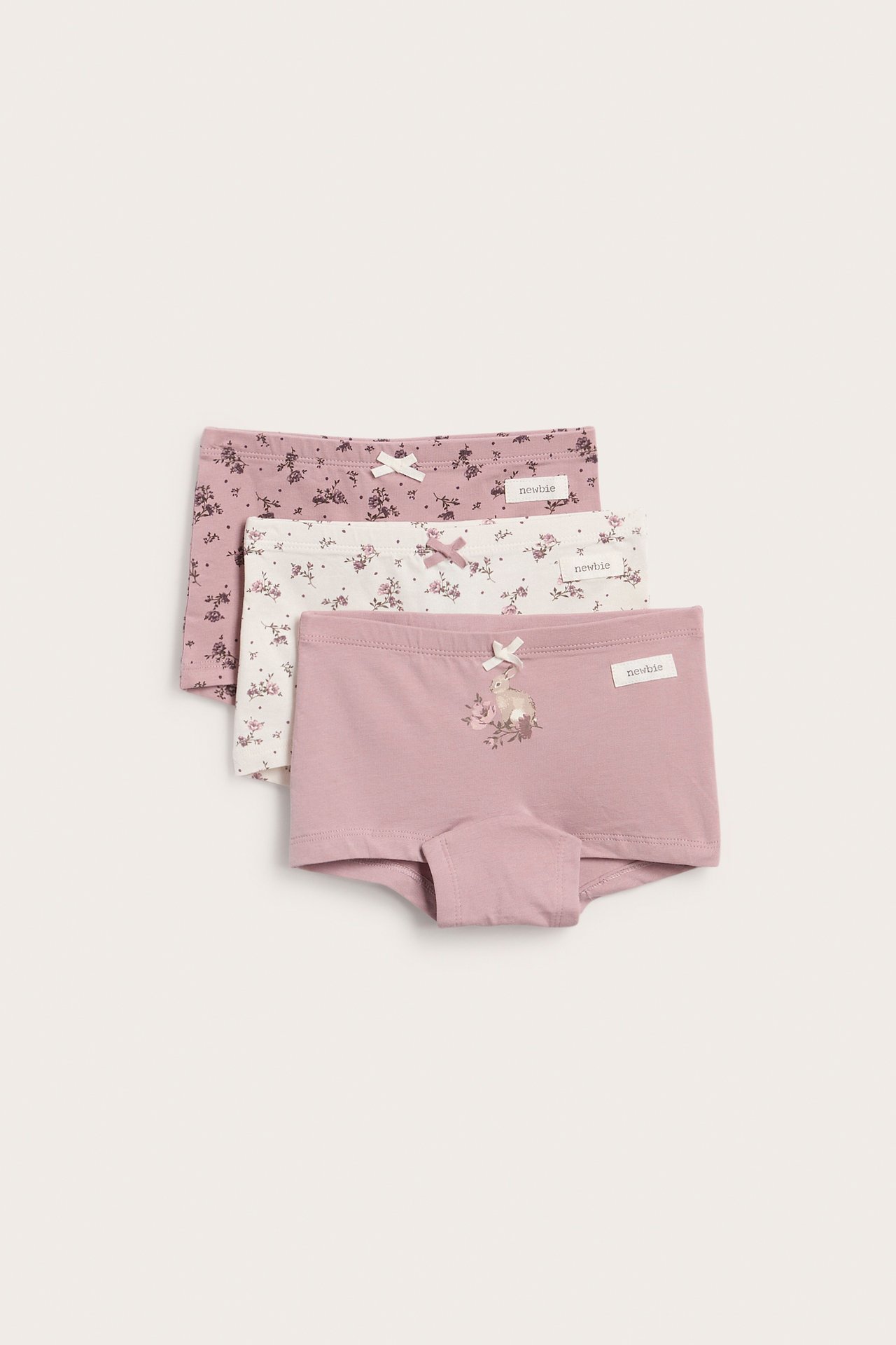 Front view of a kid's pink and floral 3-pack of jersey boxer briefs with small bows.