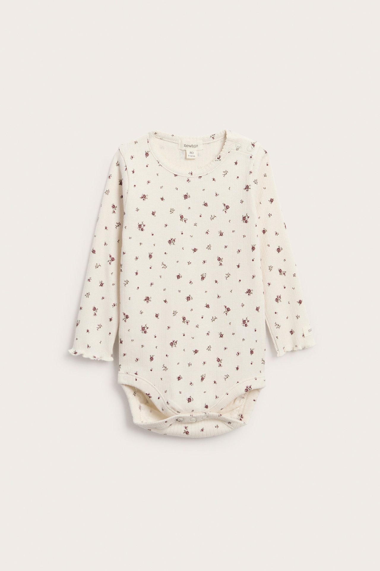 Vorderansicht eines gerippten, cremefarbenen Baby-Langarmbodys mit Blumenmuster.