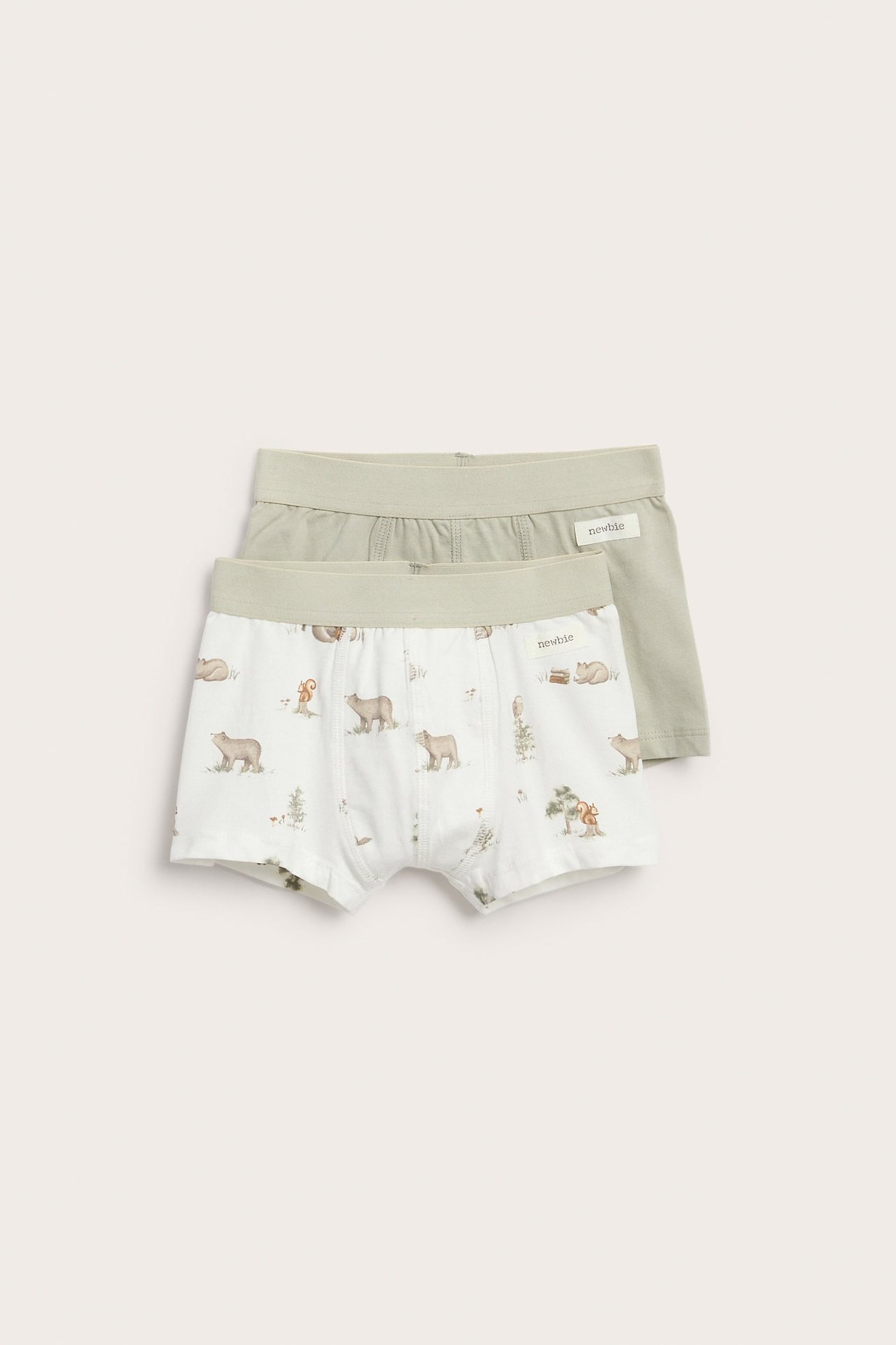 Vorderansicht von zwei Kinder-Boxershorts: eine weiße mit Bärendruck und eine einfarbige hellgrüne.