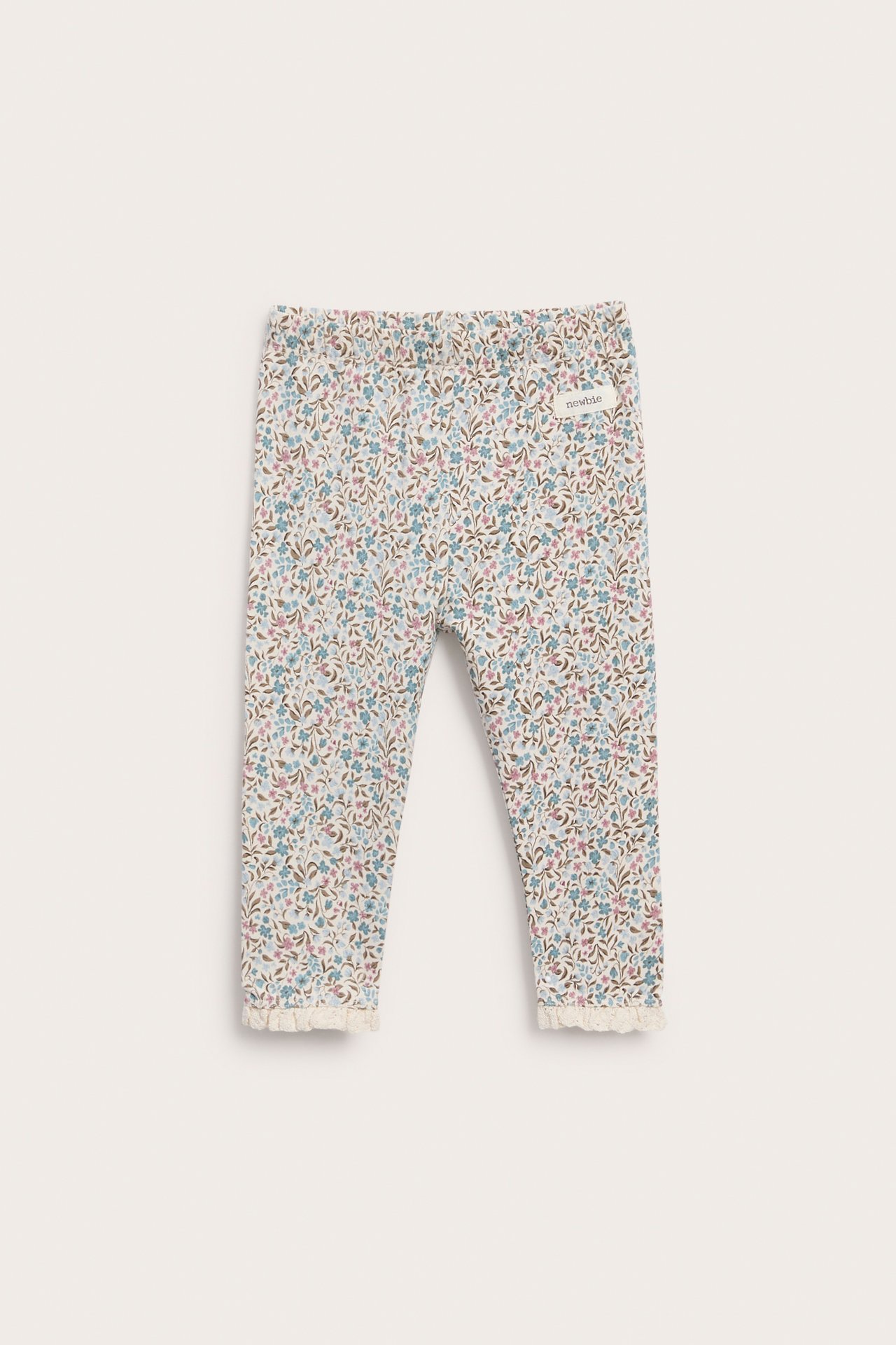 Vorderansicht von Baby-Leggings mit Blumenmuster und Spitzenbesatz an den Knöcheln.