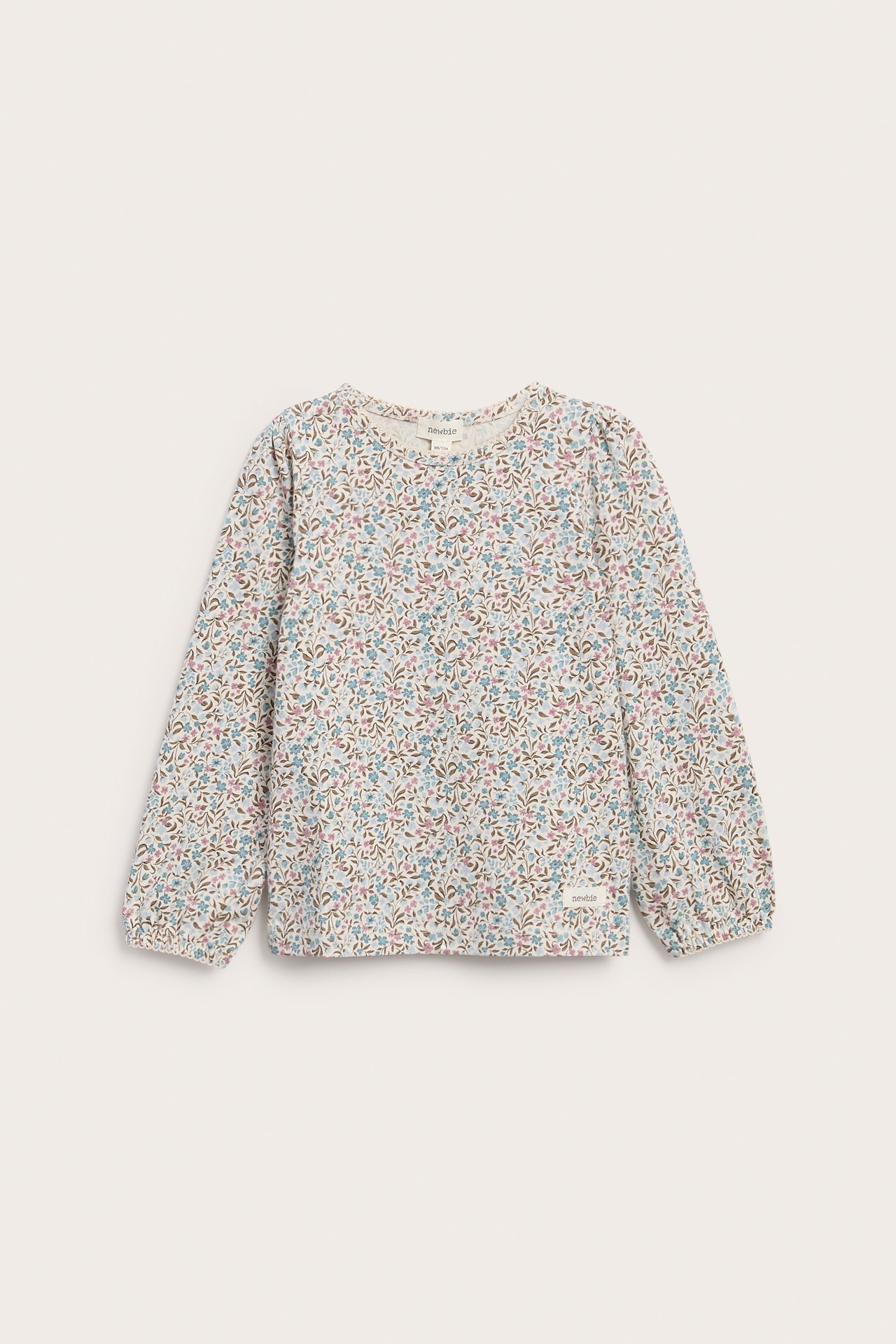 Vorderansicht eines langärmeligen Kinder-Tops in Wollweiß mit buntem Blumenmuster.