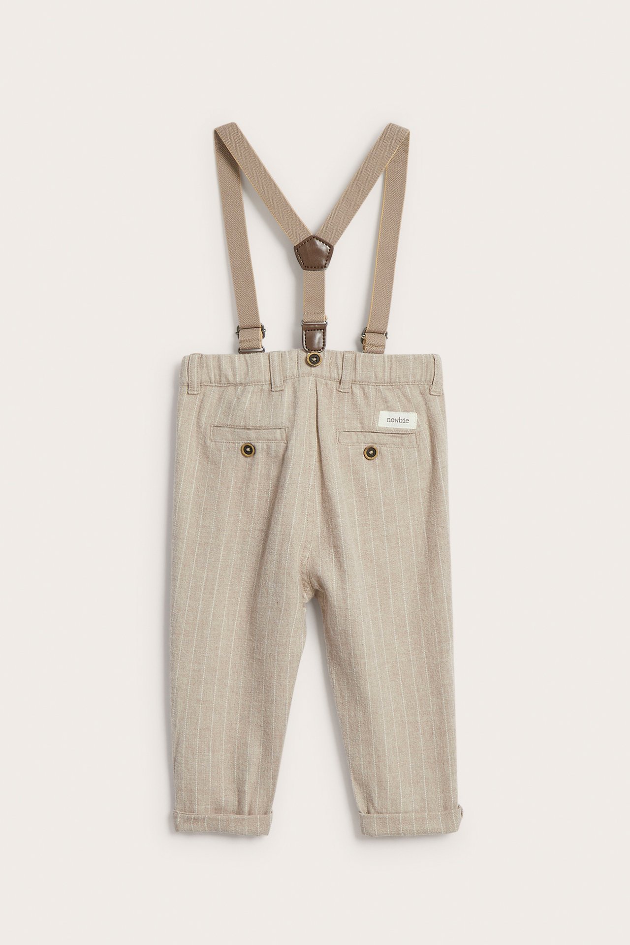 Rückansicht: Baby-Nadelstreifenhose in Beige mit Krempen und braunen Hosenträgern.
