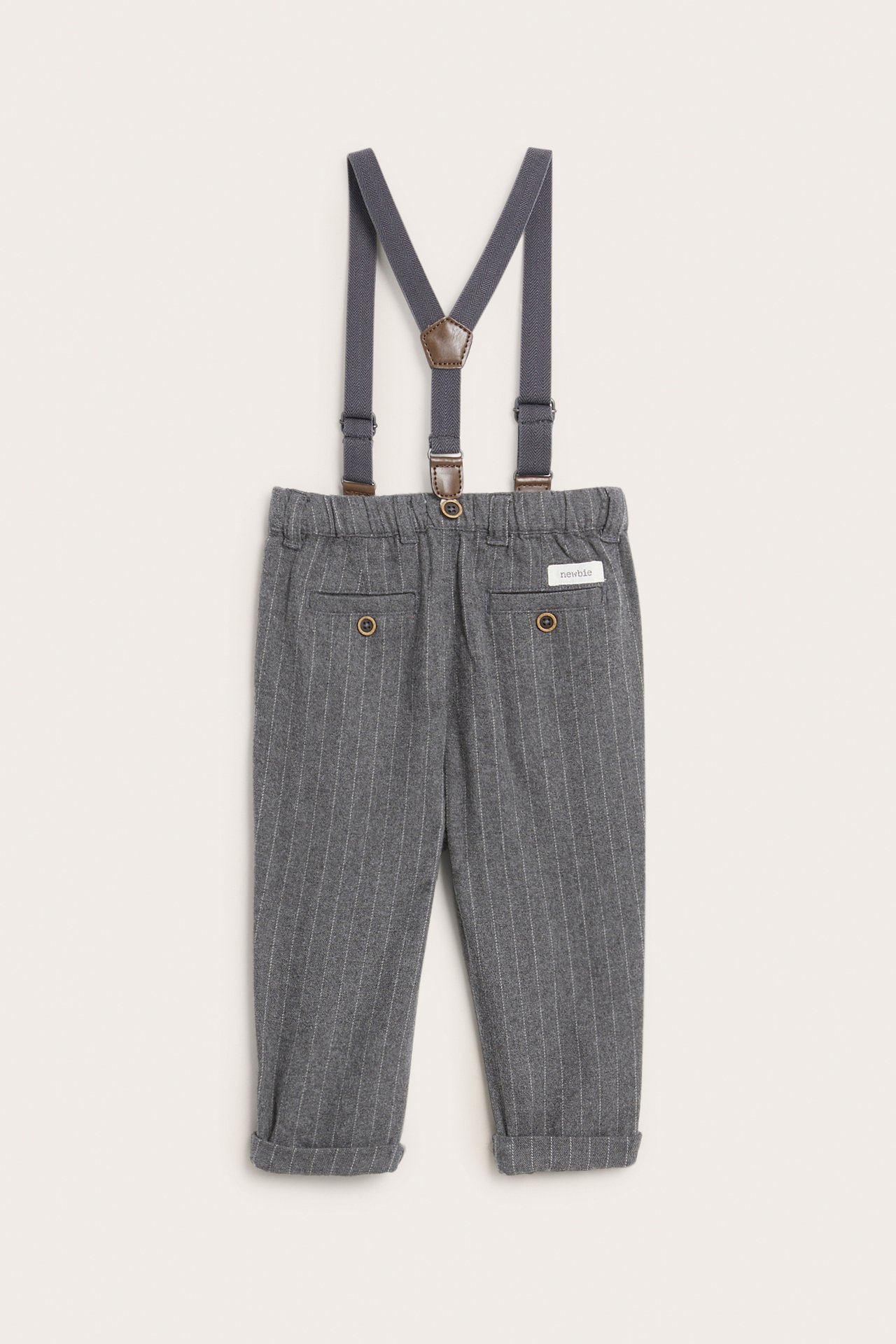 Front view of baby boy's grey pinstripe trousers with cuffed hems and grey suspenders.